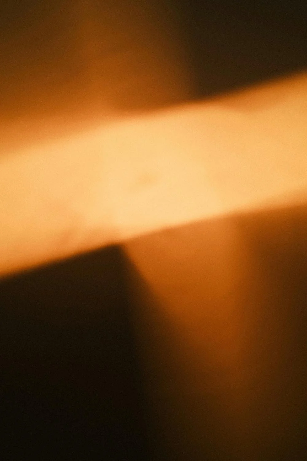 Abstraktes warmes goldenes Lichtglühen erzeugt eine sanfte atmosphärische Stimmung.