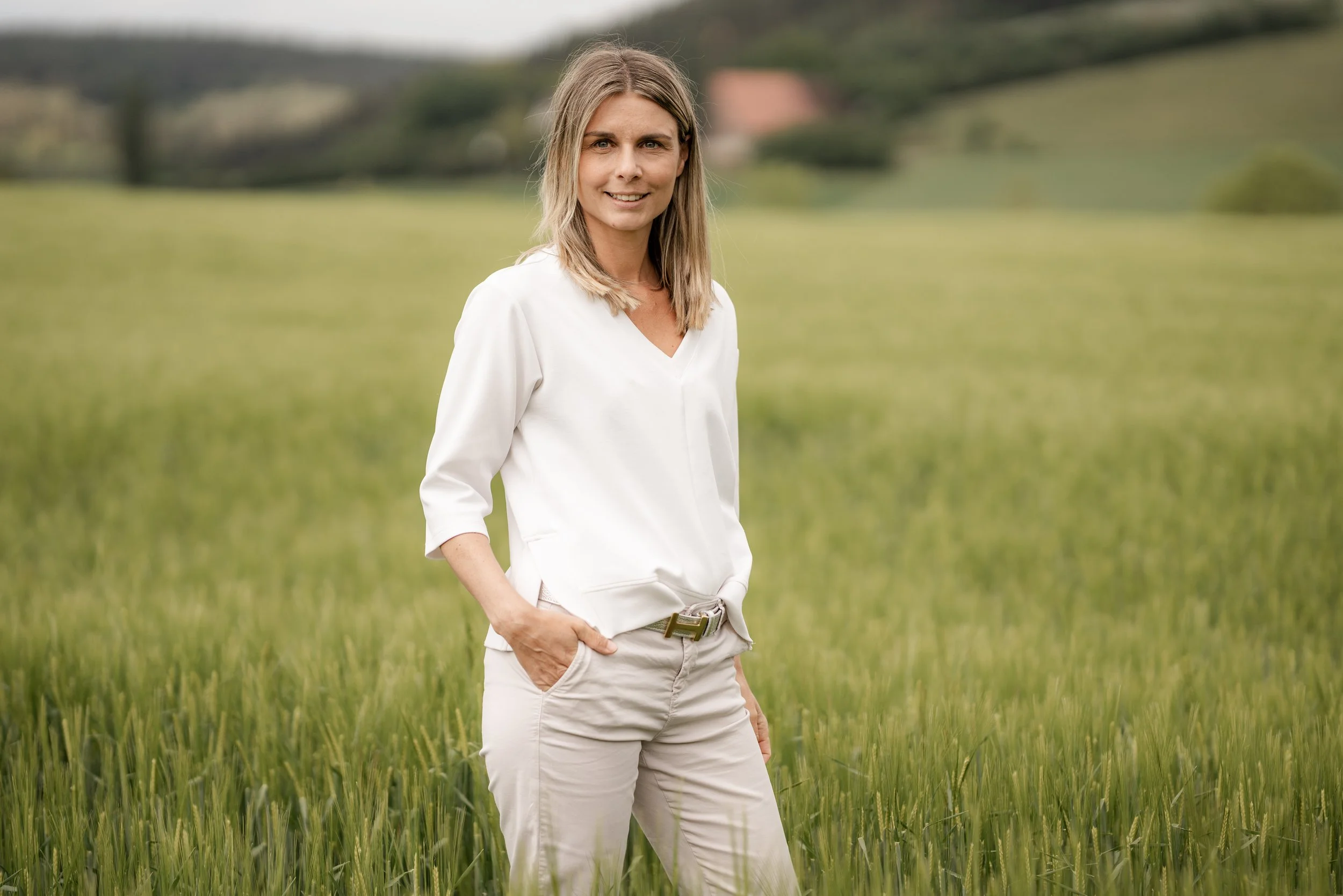 Laura Kather – Life Coach und Personal Styling Coach Nürnberg – steht lächelnd in einem Kornfeld bei Nürnberg