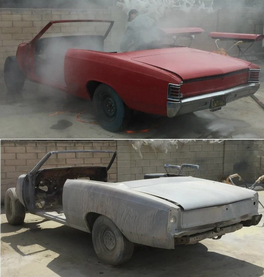 The image shows two classic cars in different stages of restoration or disrepair. The top car is a red convertible with smoke around it, possibly being painted or repaired, with two shop lights in the background. The bottom car is a stripped-down, mo