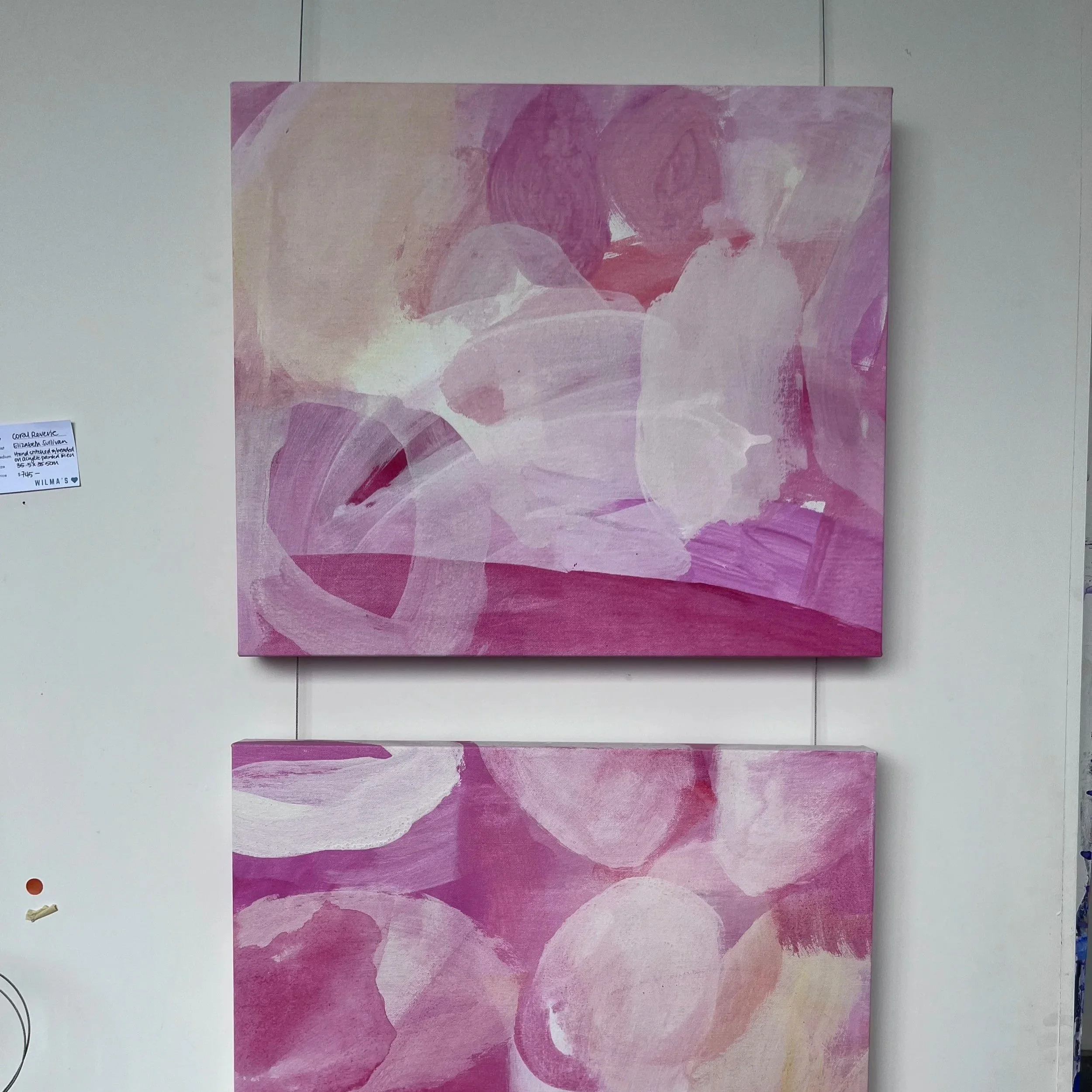 Abstract painting with shades of pink, purple, and beige on a canvas displayed on a white wall.