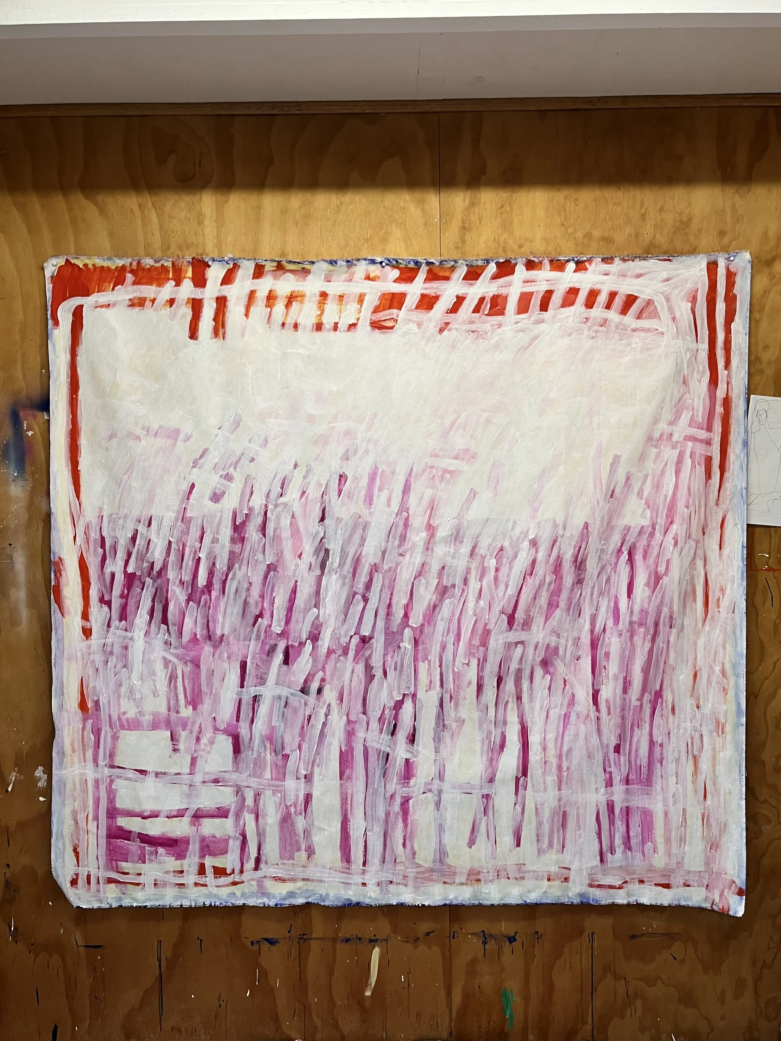 Abstract painting with red, pink, white, and orange brushstrokes on a canvas, mounted on a wooden wall.