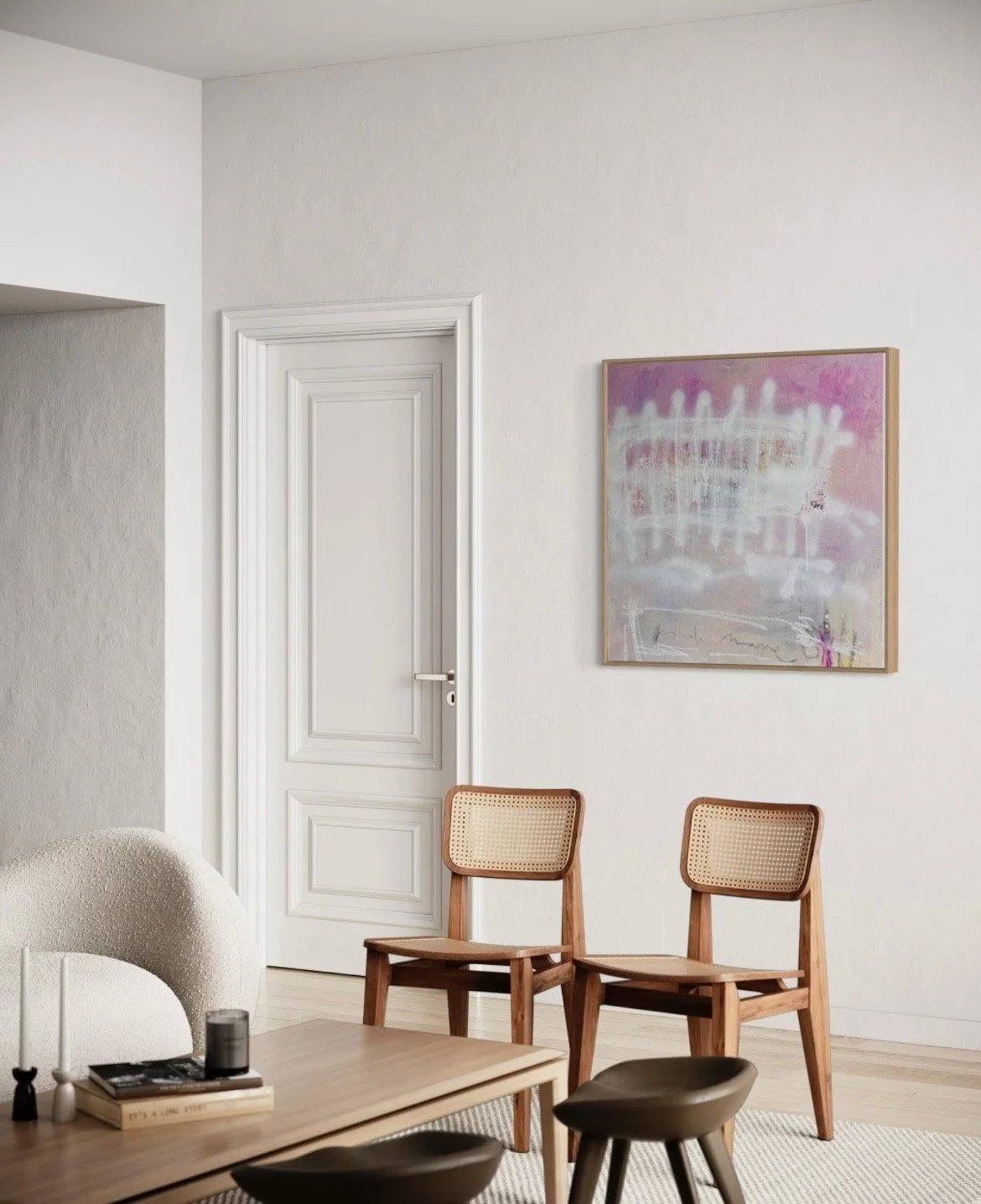 A corner of a modern, minimalist living room with white walls, a white door with decorative molding, two wooden chairs with cane backrests, and an abstract pink and purple painting hanging on the wall.
