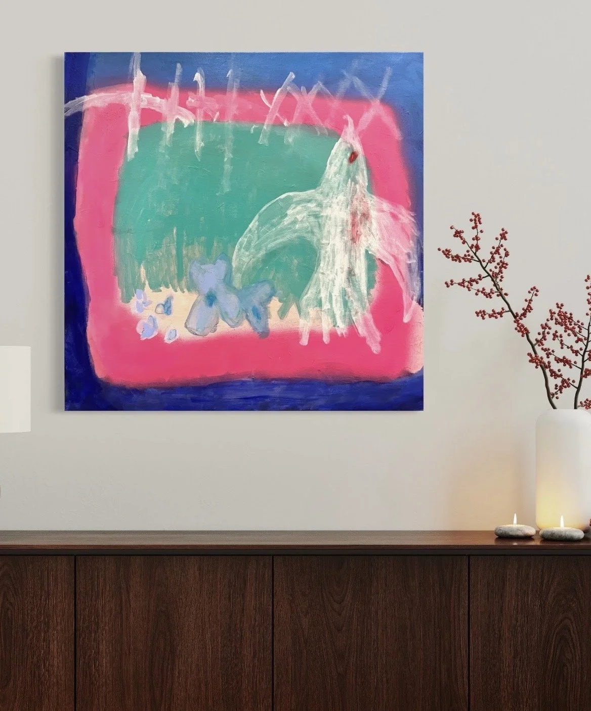 Abstract children's painting with bright colors, featuring a green shape with pink, blue, and white accents, hung on a white wall next to a decorative plant with red berries and two candles on a wooden cabinet.