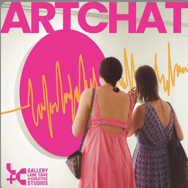 Two women are viewing a large poster or artwork at an art gallery, with pink and yellow organic shapes and the word "ARTCHAT" in large pink letters at the top.