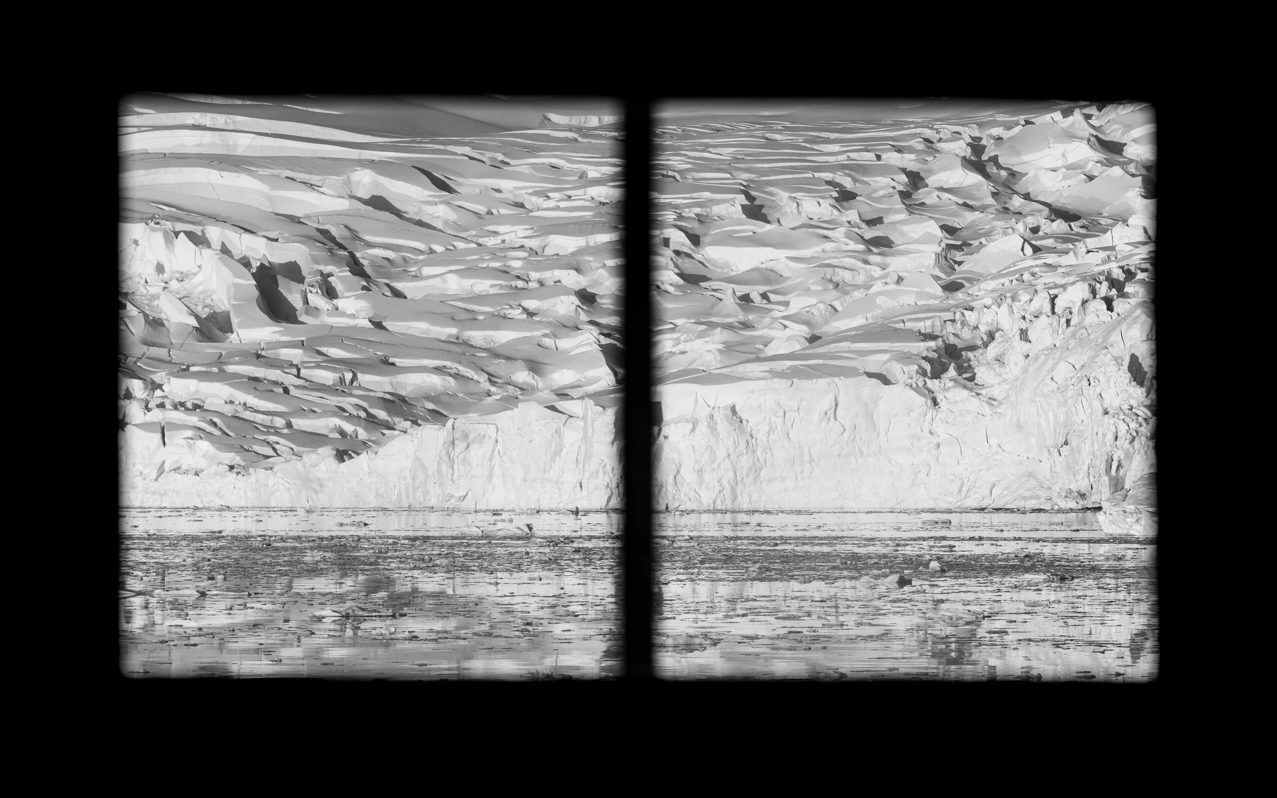 A black and white photograph of a glacier viewed through a window with crossbars, with water in the foreground and large ice formations in the background.