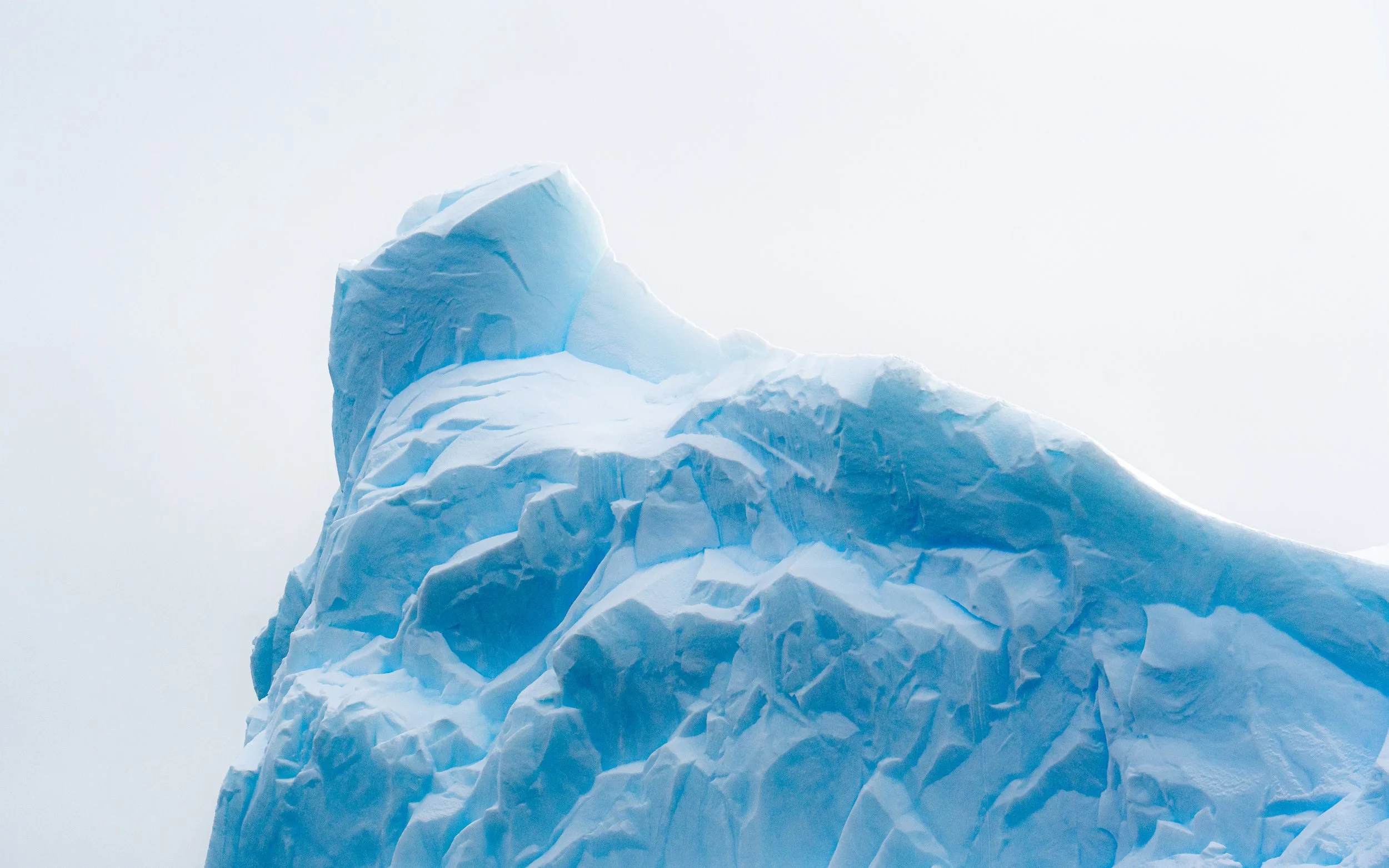 Iceberg with a sharp peak in a cloudy sky