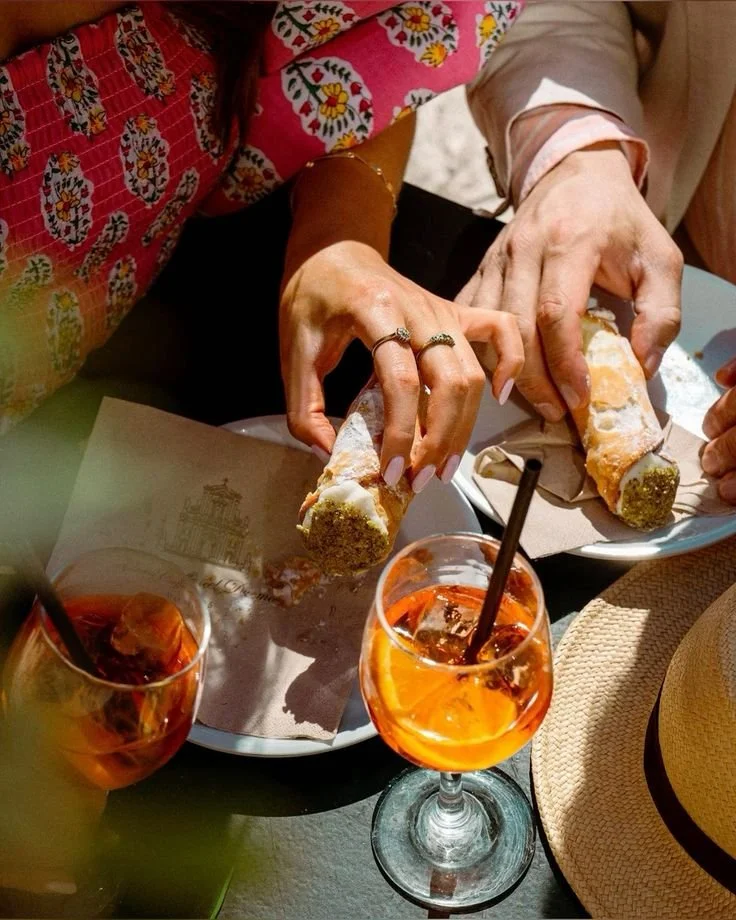 Delen van mensen die genieten van citrus- en pistache-ijsstengels en drankjes met ijs en citrus op een tafel.