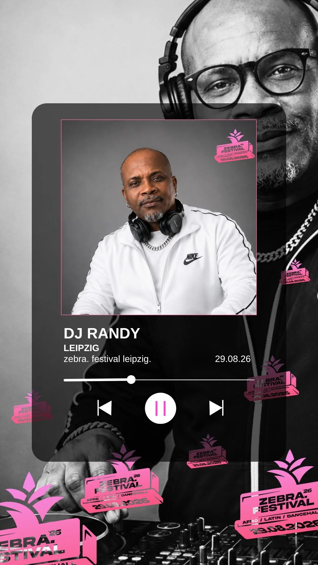 Ein Mann mit DJ-Kopfhörern um den Hals, weiße Nike-Jacke, sitzt vor einem DJ-Controller. Im Hintergrund eine große, schwarze und weiße Porträtaufnahme eines Mannes, der ebenfalls DJ-Kopfhörer trägt. Überlagerte pinkfarbene Festival-Logos mit der Aufschrift "Zebra Festival 2026" und dem Datum 29.08.26.