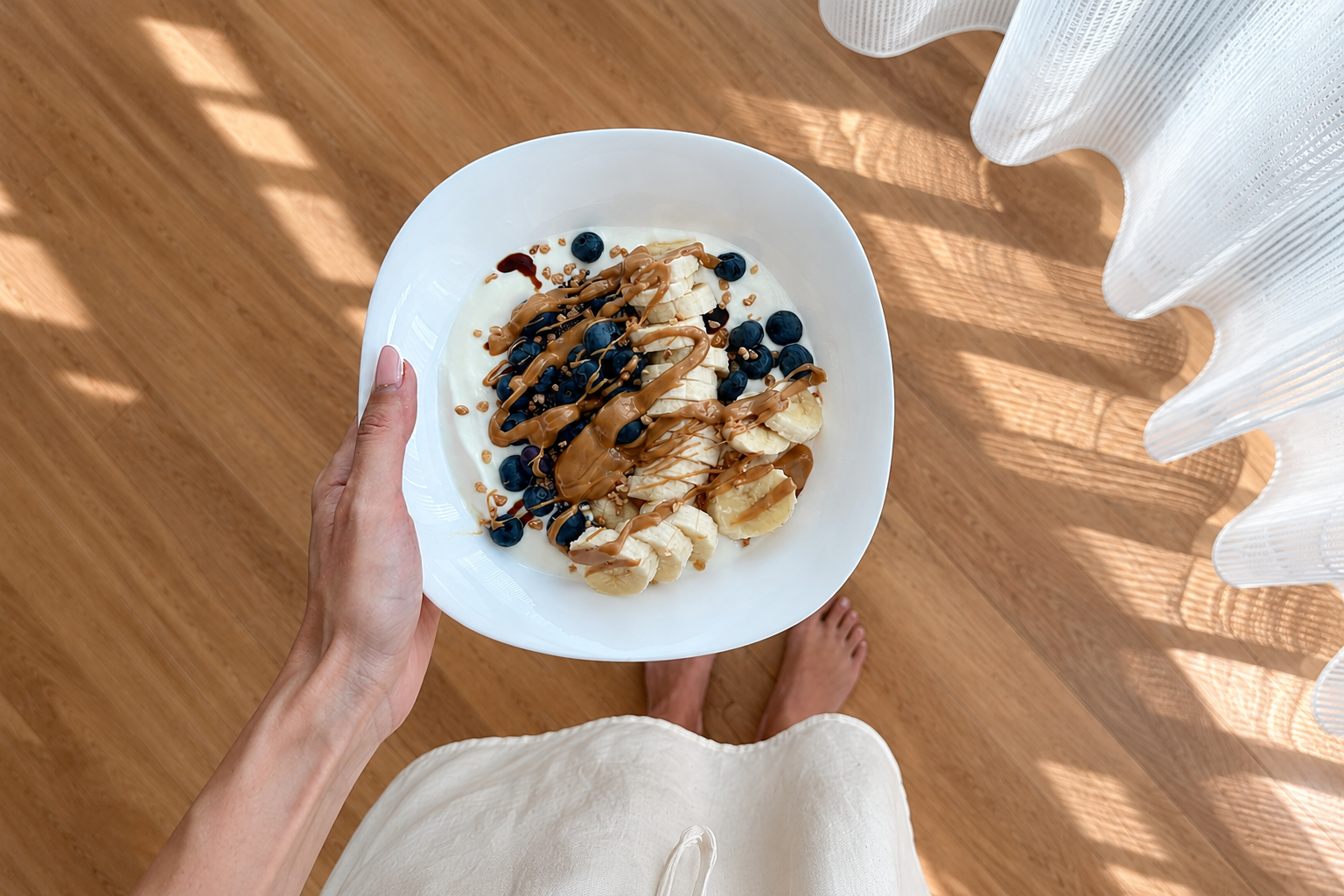 Balanced breakfast bowl with Greek yogurt, blueberries, banana, granola, and chocolate drizzle.
