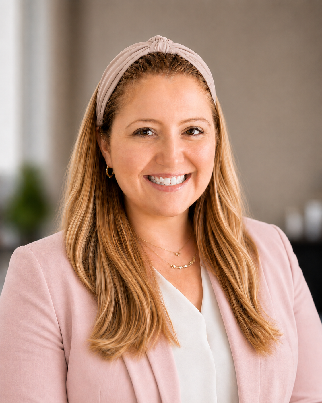 Registered Dietitian and media nutrition expert Laney Miller smiling, while wearing a pink blazer and beige headband.