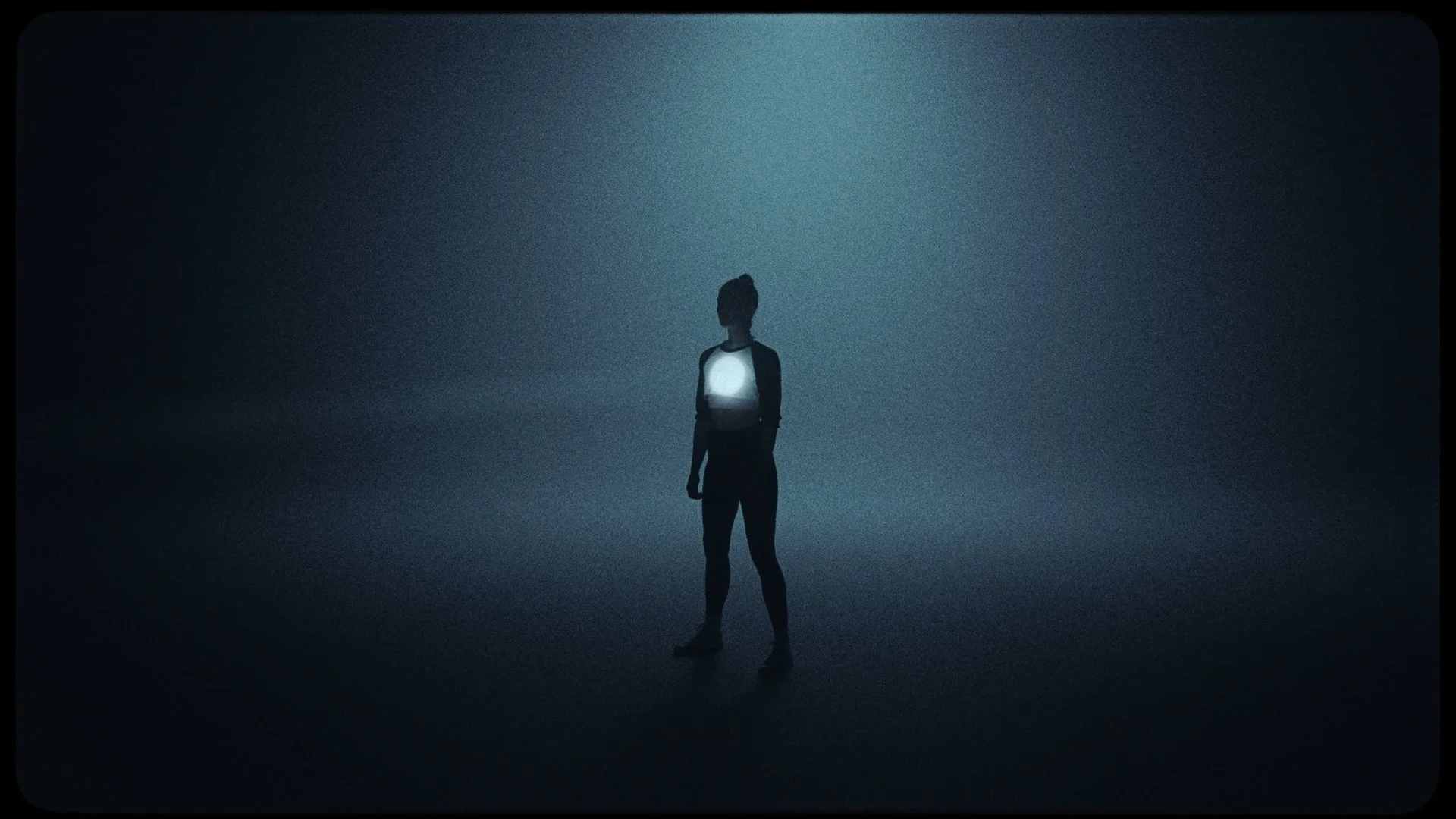 Silhouette of a woman standing in a dark, foggy environment with a bright light source on her chest, illuminated against a dimly lit background.