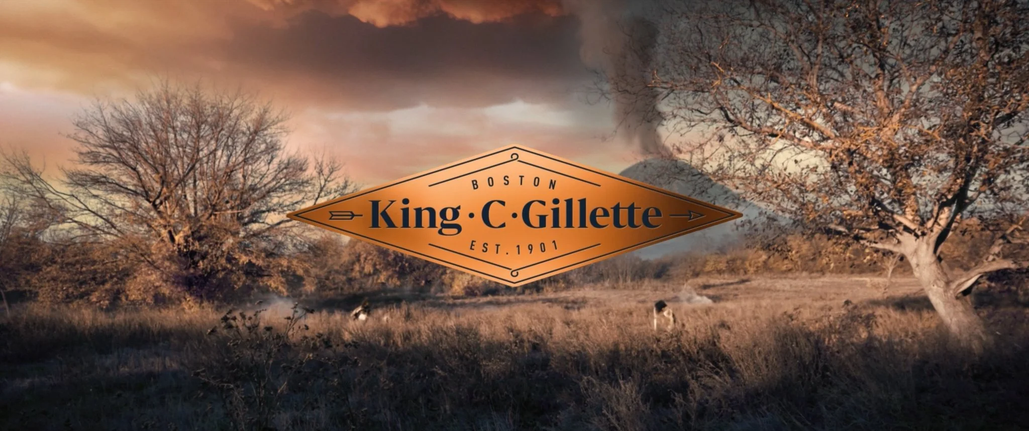 A landscape with leafless trees, a cloudy sky, and grass in warm tones. A logo in the center reads "King C. Gillette, Boston, Est. 1901."