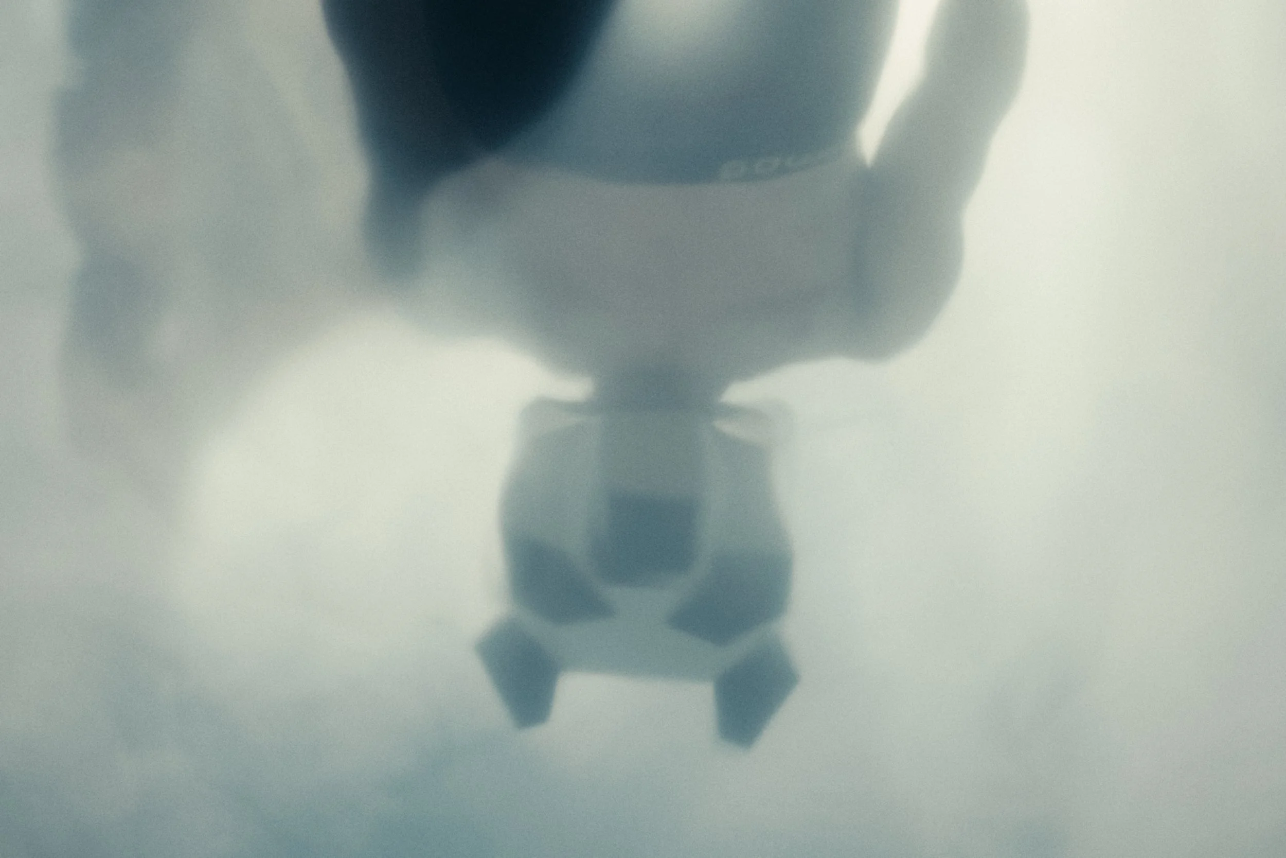 A reflection of a person taking a photo with a phone, with their hand and phone visible in the mirror.