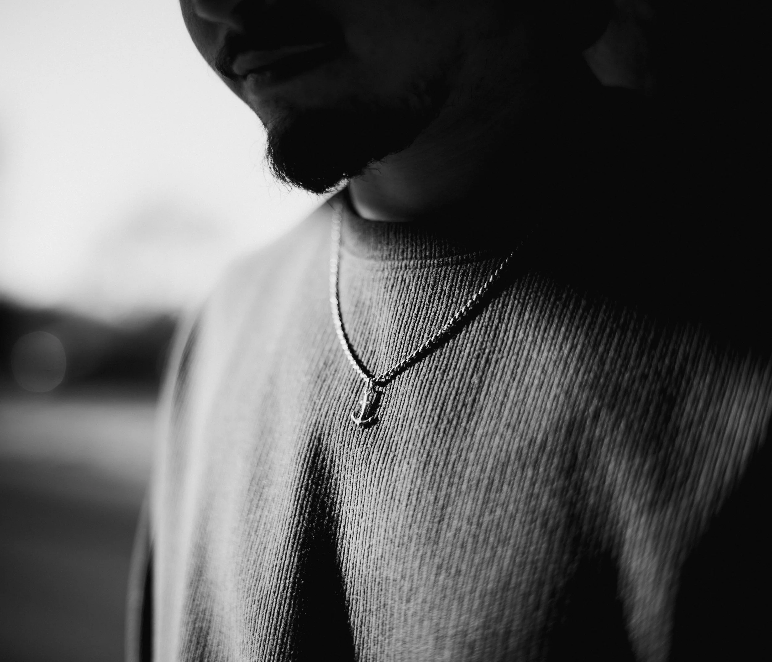 Close-up of a person's face showing only lips, beard, and part of neck, in black and white.