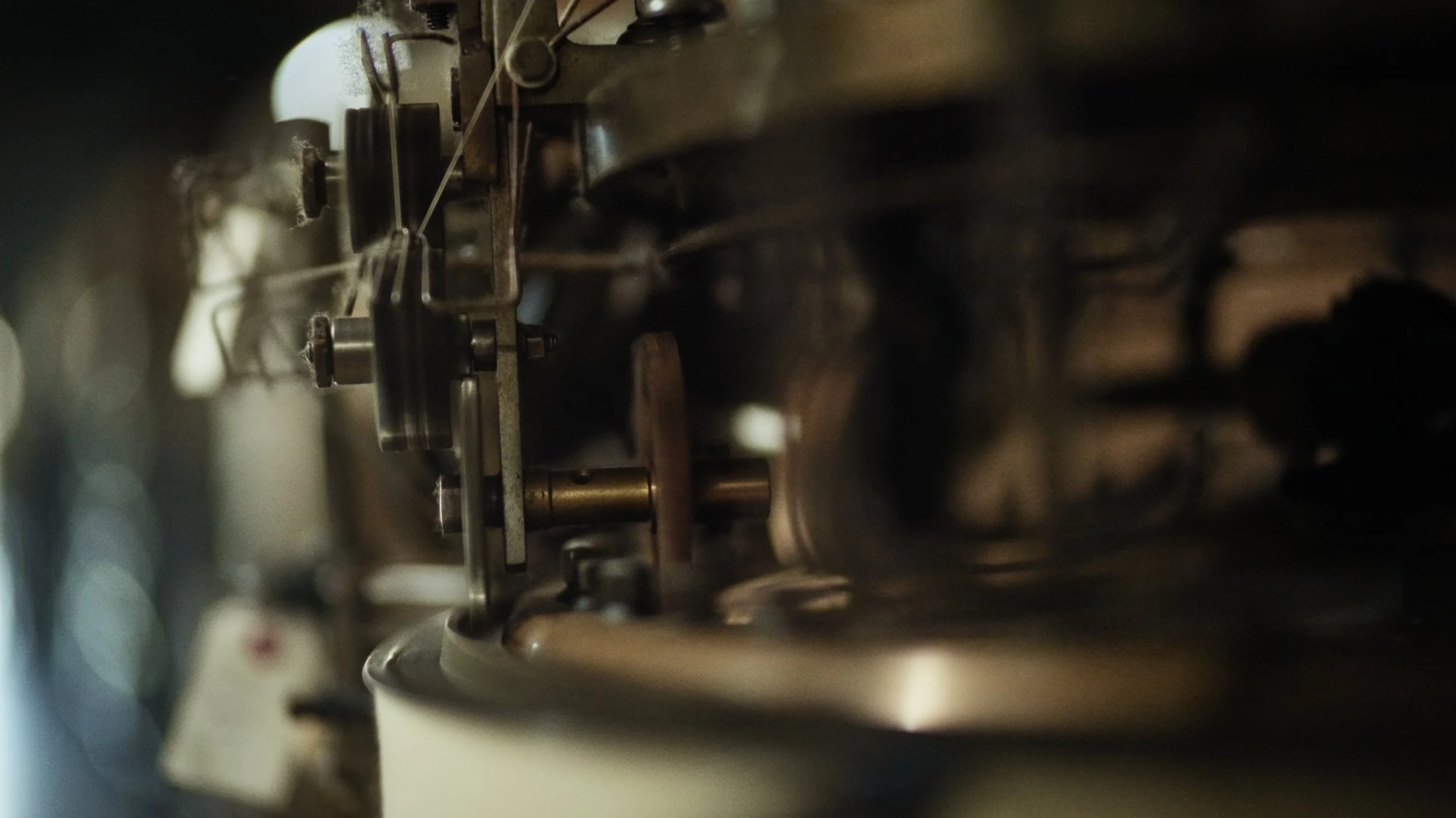 Close-up of mechanical parts inside a machine, with metal rods and gears, in a dark environment.