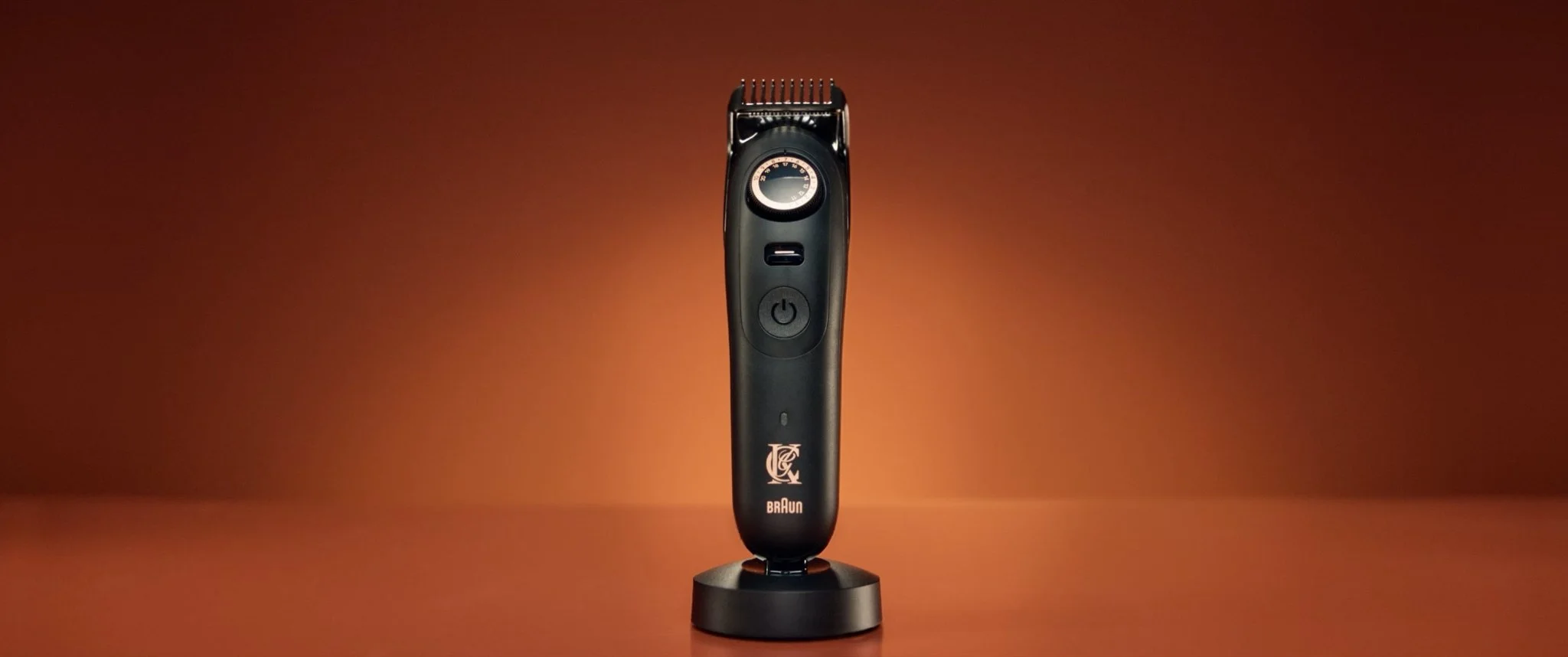 Black electric trimmer placed on a stand against a brown background.