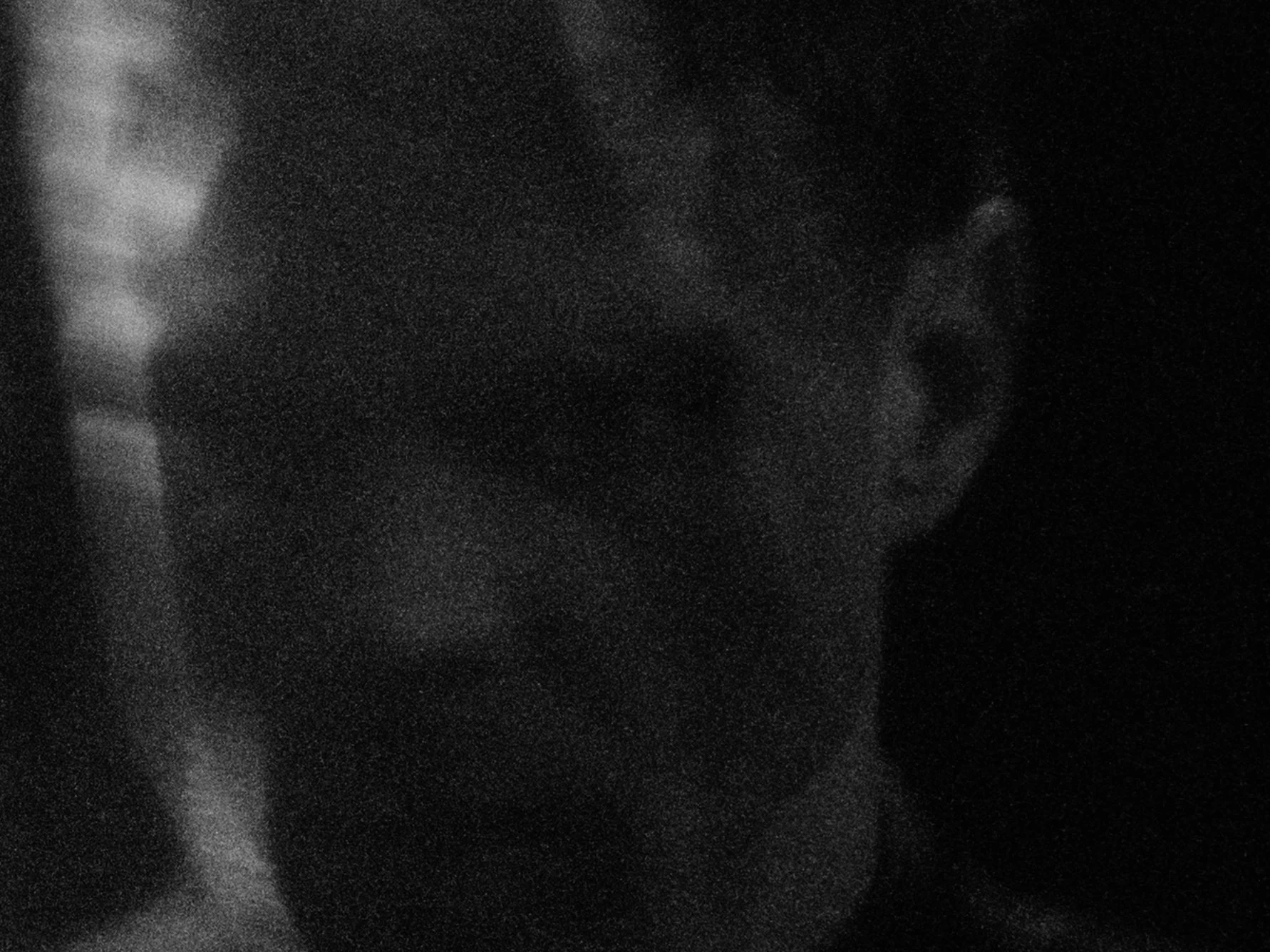 Close-up of a human face with a somber expression, in black and white.