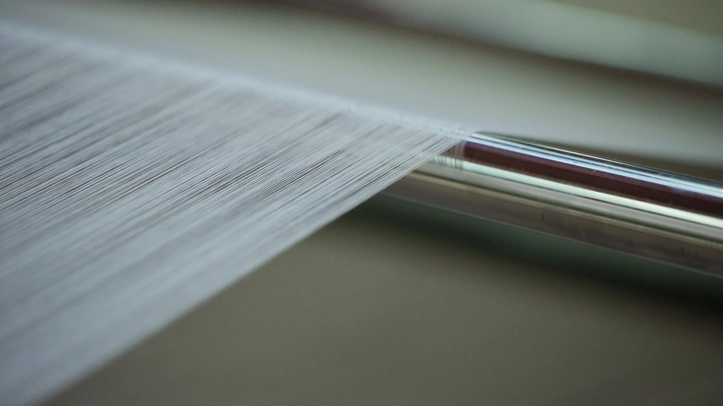 Close-up of a printing press or copier machine releasing a sheet of paper with printed lines.