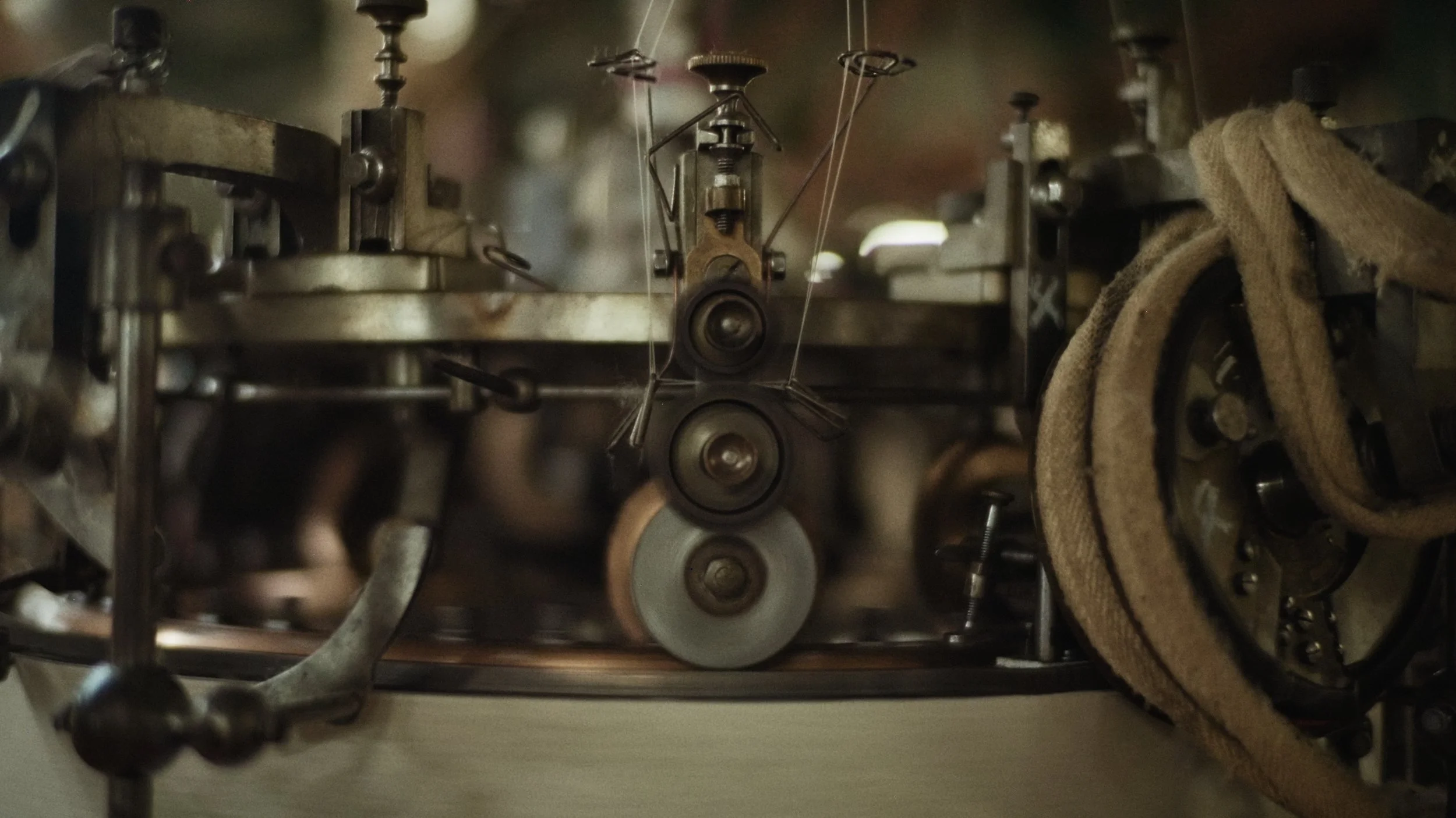 Close-up of a mechanical clock mechanism with gears, pulleys, and belts, with a cloth draped over part of the machinery.