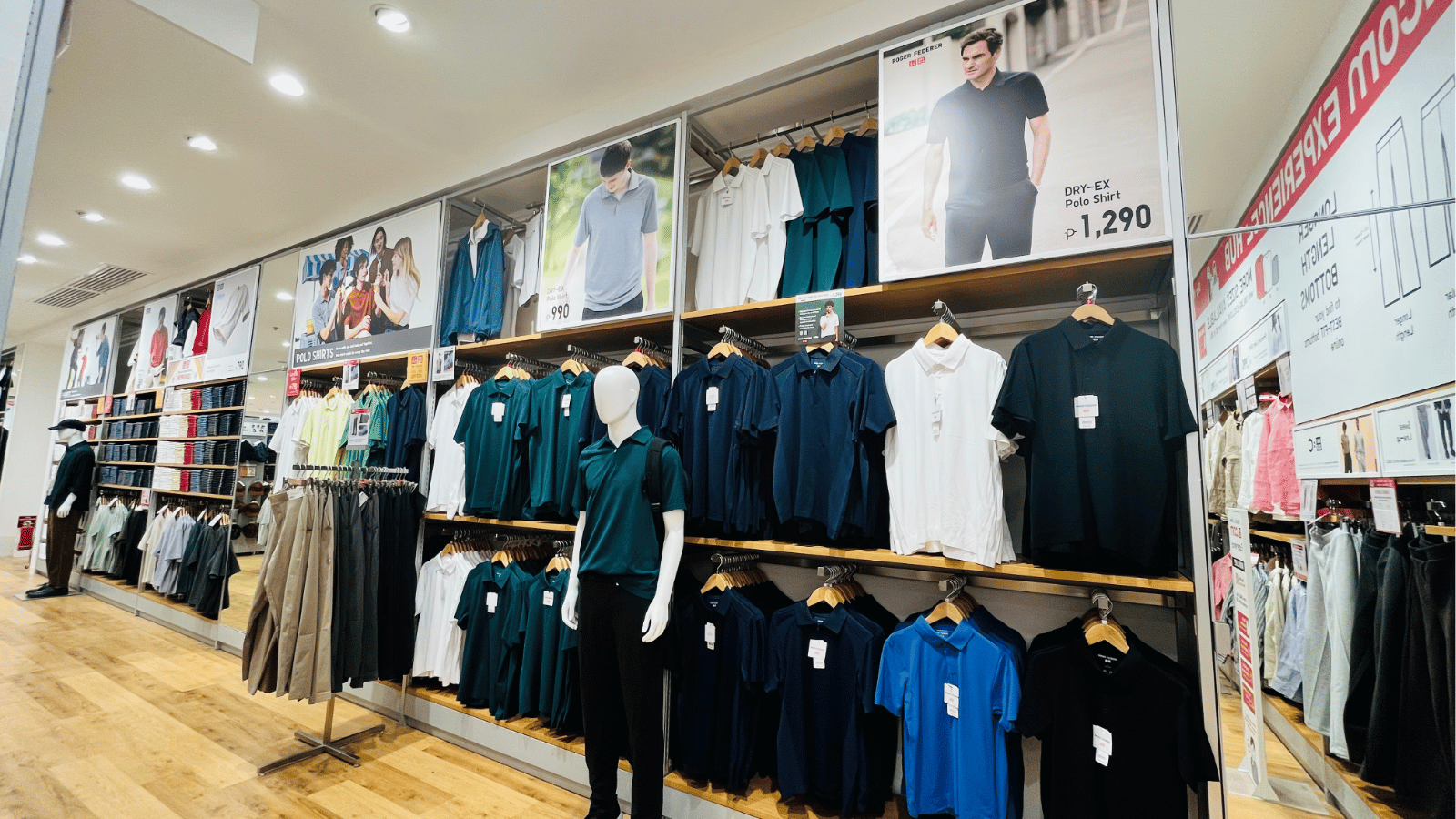Mannequin wearing a polo shirt inside a UNIQLO store with shelves of polo shirts and other apparel.