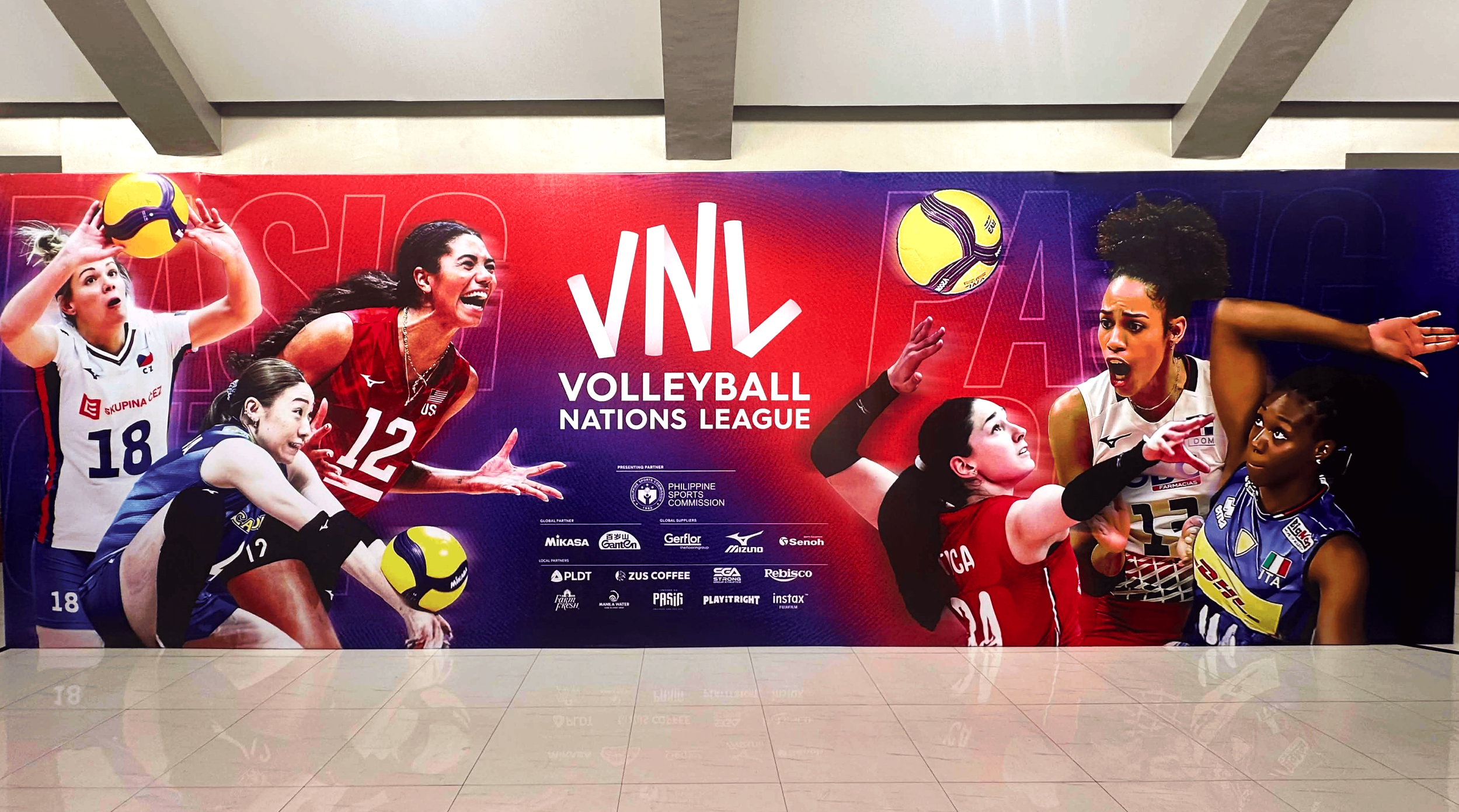 A colorful poster featuring female volleyball players in action, promoting the Volleyball Nations League, with various sponsor logos at the bottom.