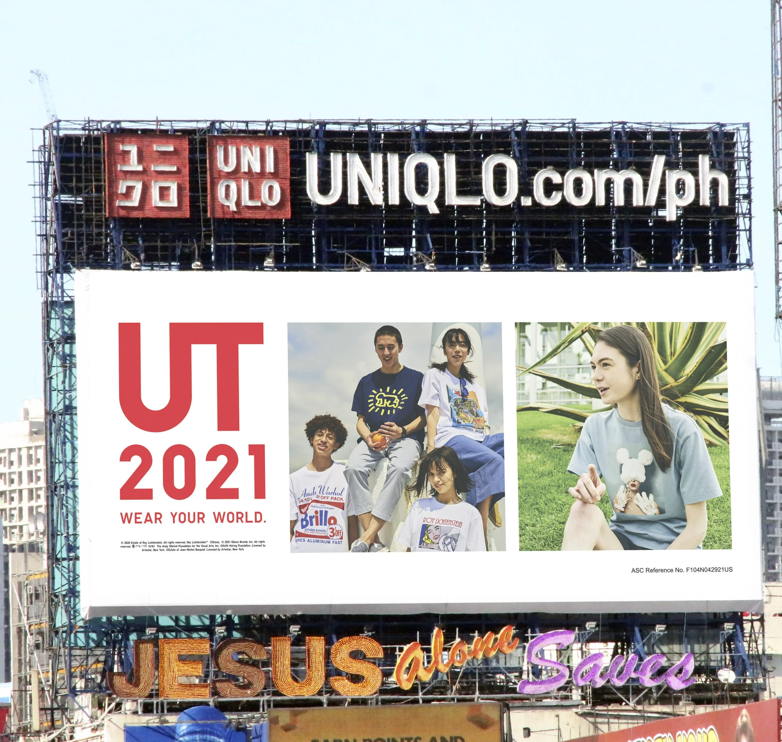 Large billboard with bright neon signs, including a 'Welcome' sign and images of diverse young people outdoors, with some holding ice cream and snacks, under a clear sky.