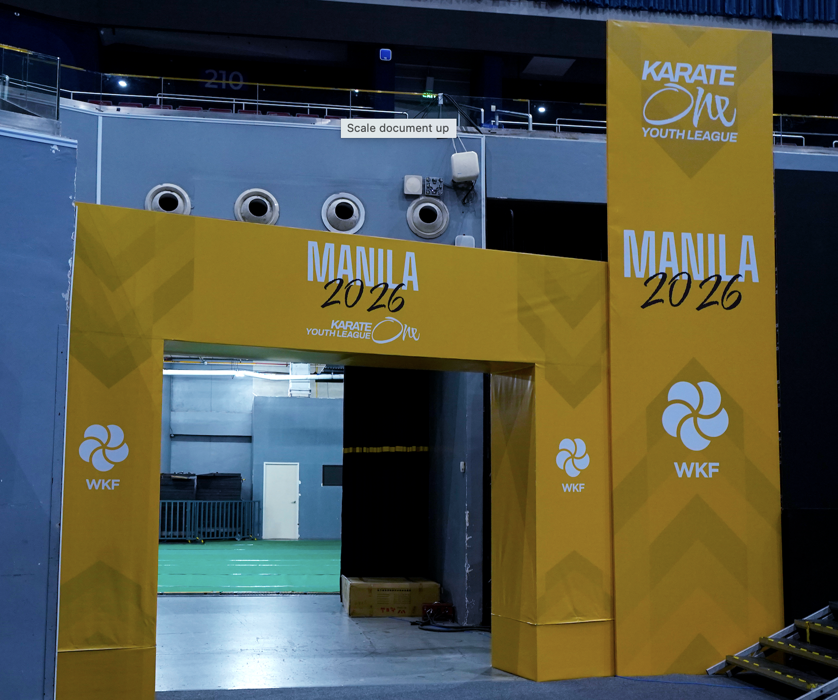 Entrance to a sports arena with yellow branding for the 2026 Manila Karate Youth League, WKF logo, and a doorway leading into an indoor sports venue.