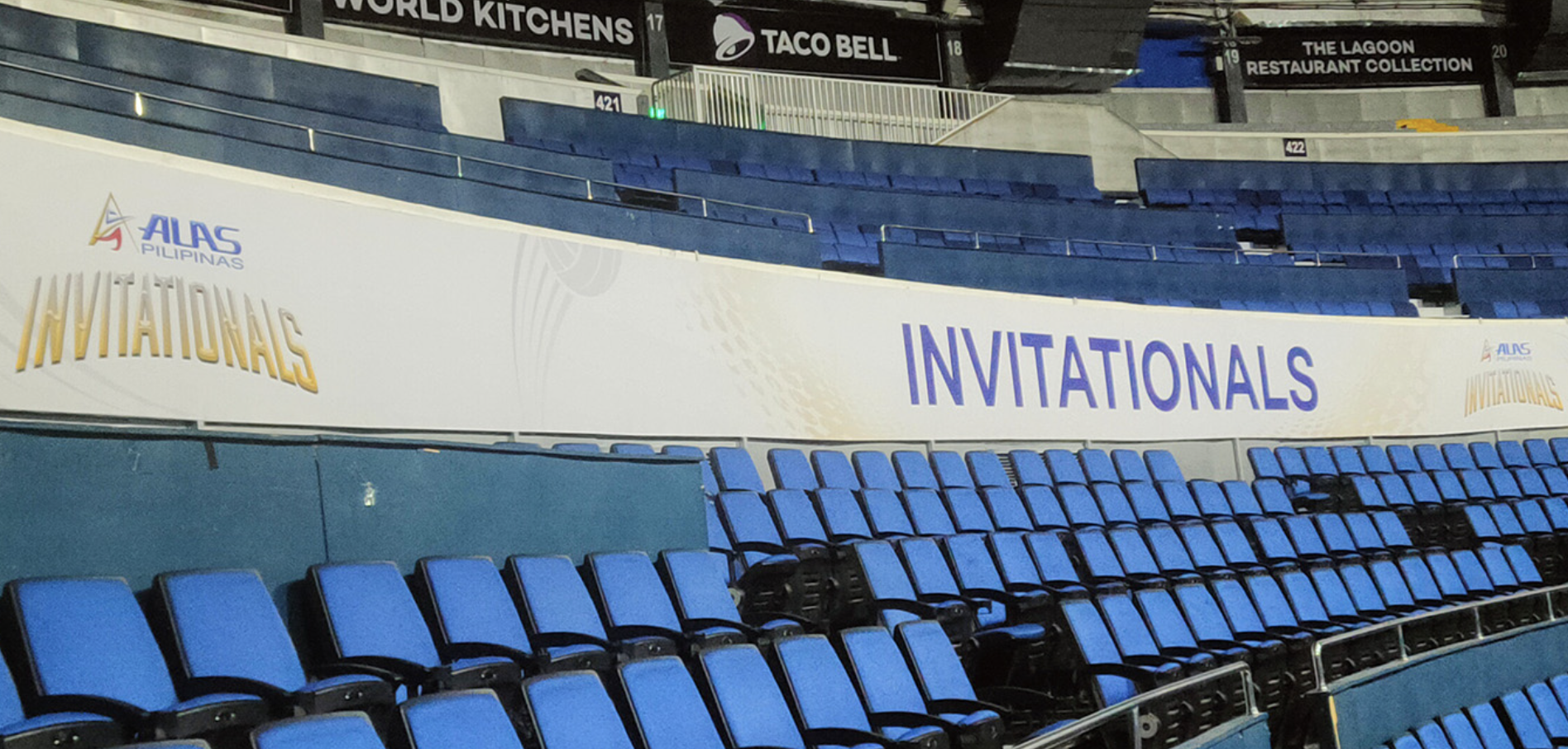 An indoor arena with blue seats and a large banner reading 'INVITATIONALS' for the ALAS Pilipinas event
