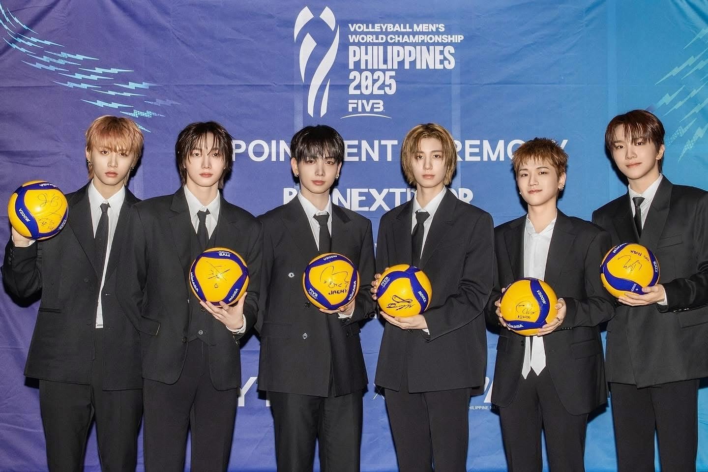 Six young men in black suits and white shirts standing in front of a blue background with the words "Volleyball Men's World Championship Philippines 2025". Each is holding a signed yellow and blue volleyball.