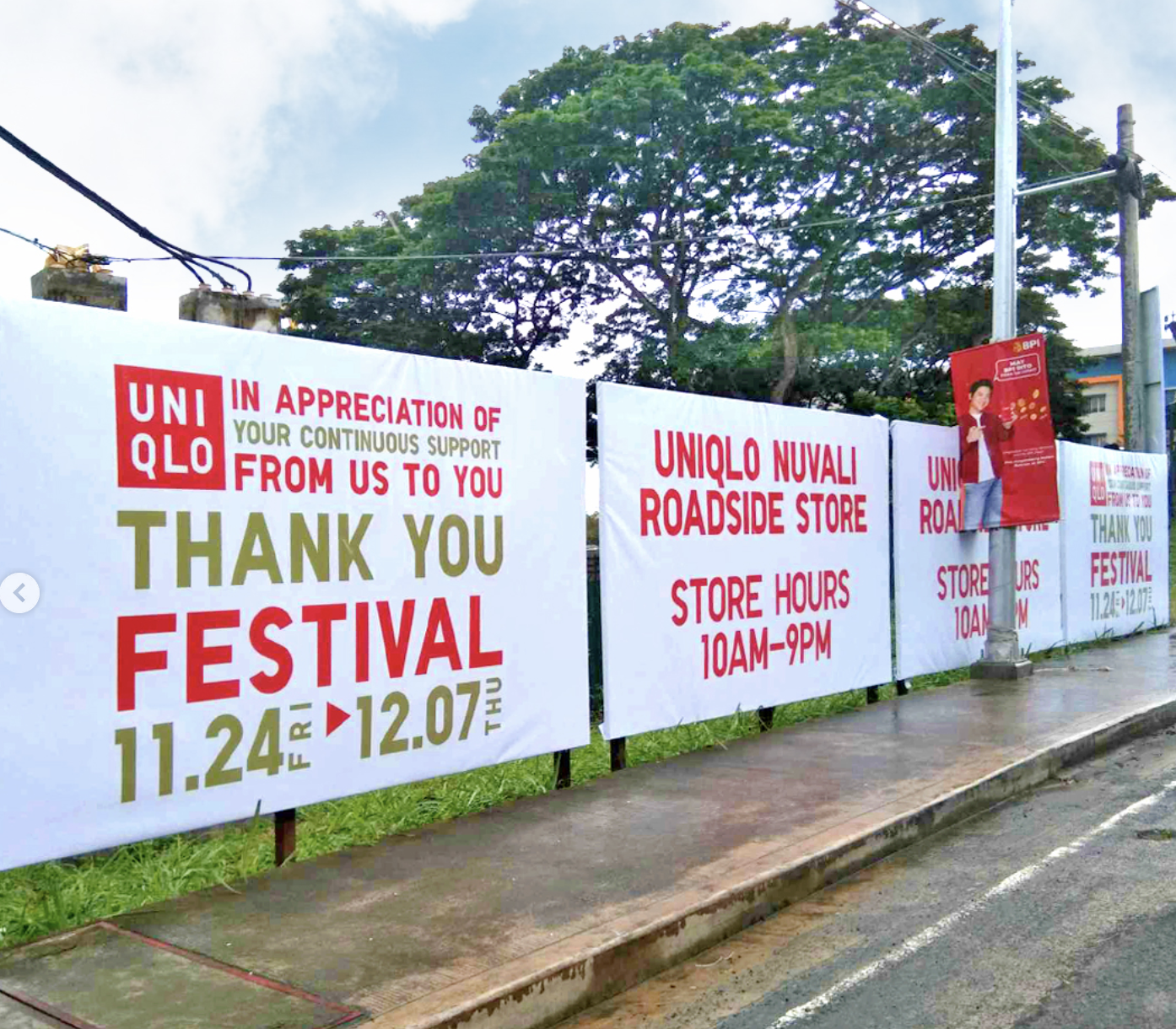 Banners on a fence expressing appreciation for support during a festival, with event dates from November 24 to December 7, and details about a UNIQLO roadside store with hours from 10 AM to 9 PM.
