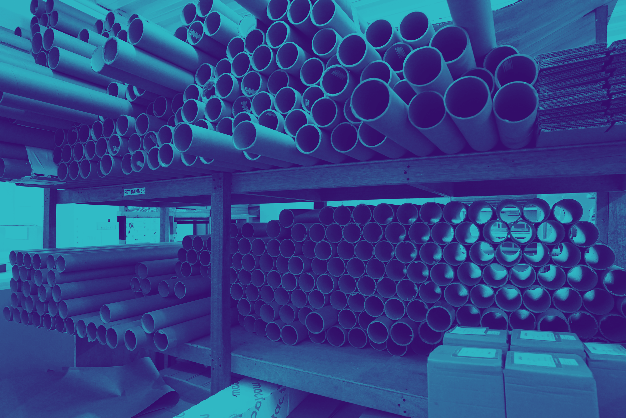 A storage shelf holding numerous white cardboard tubes and boxes