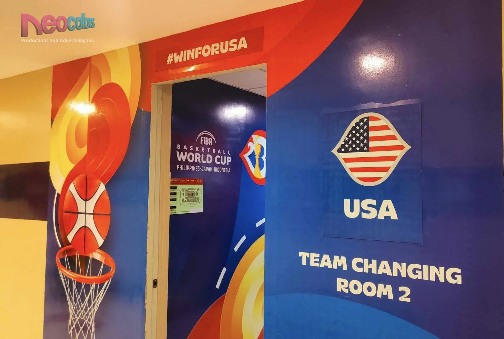 Wall with colorful sports-themed graphics, including a basketball hoop and USA team changing room sign for the FIBA Basketball World Cup.