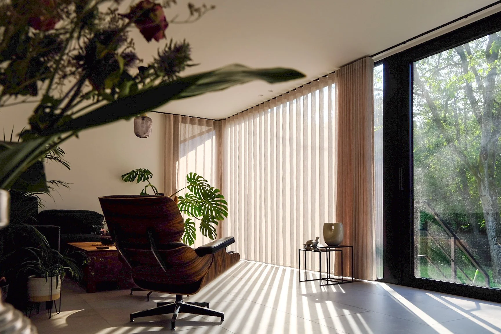 Spacious living room design with large floor-to-ceiling windows and natural light integration, by Tom Naeyaert Architecture.