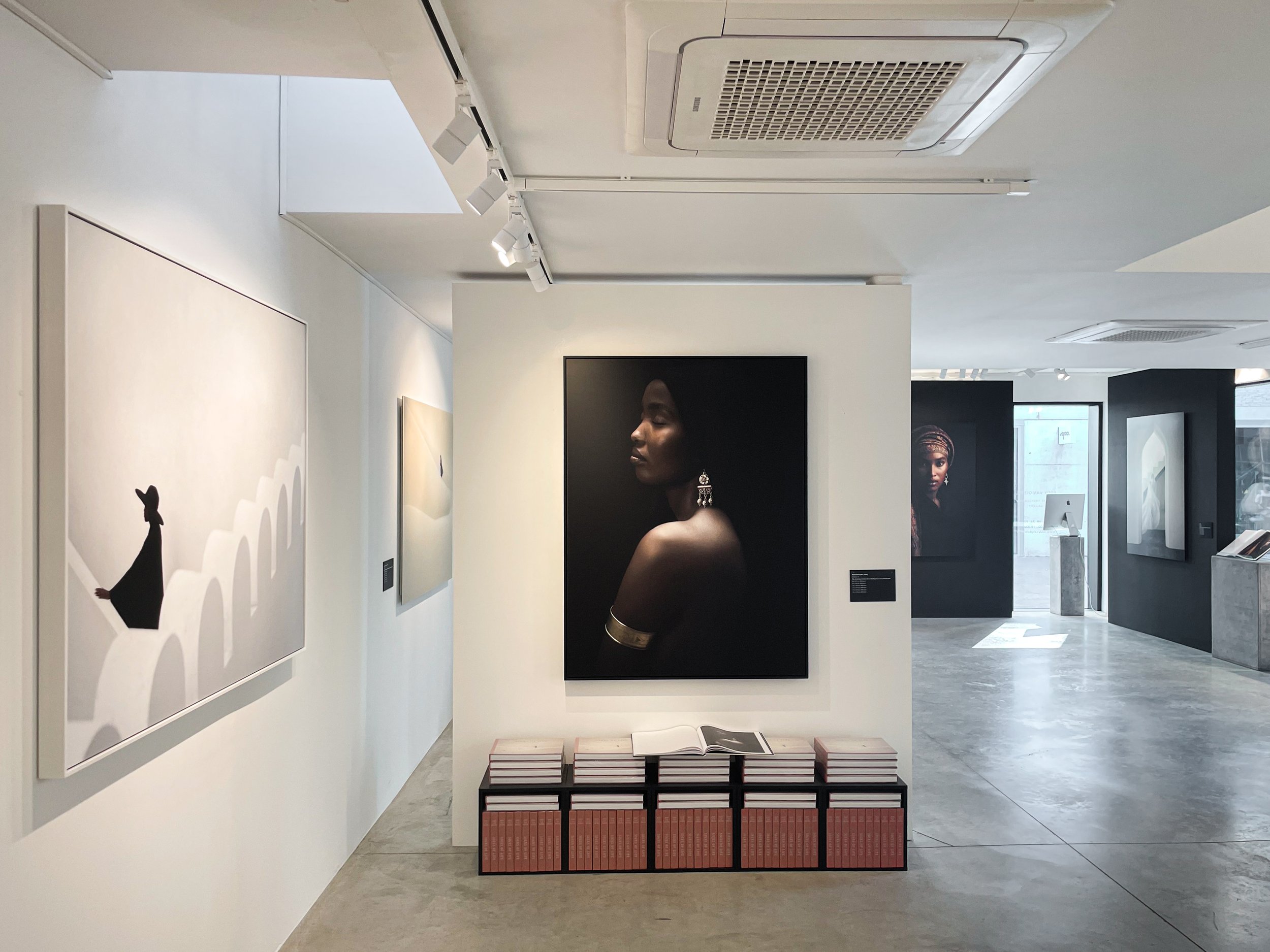 Modern gallery interior with custom lighting and bespoke exhibition furniture design, crafted by Tom Naeyaert Architecture in Antwerp.