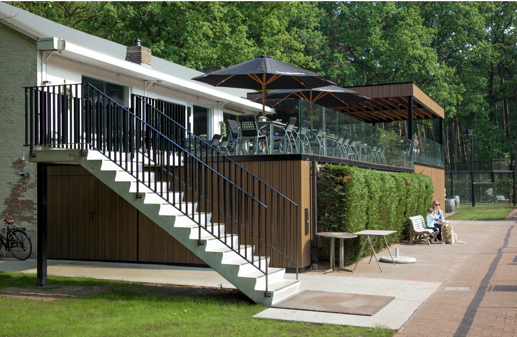 Outdoor patio and exterior architecture for a modern pavilion and clubhouse, designed by Tom Naeyaert Architecture.