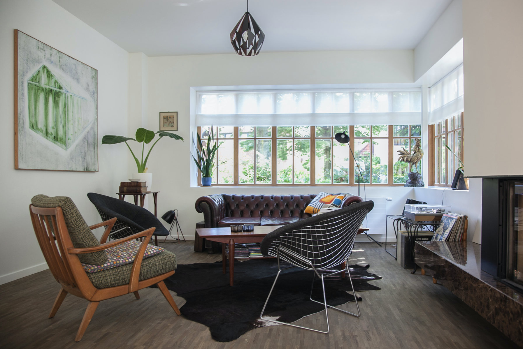 High-end residential interior design for a modern living room featuring large windows and natural light, by Tom Naeyaert Architecture.