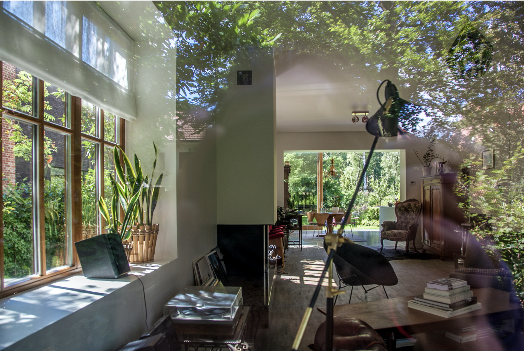 Bright and spacious residential living room design with large windows opening up to the garden, by Tom Naeyaert Architecture.