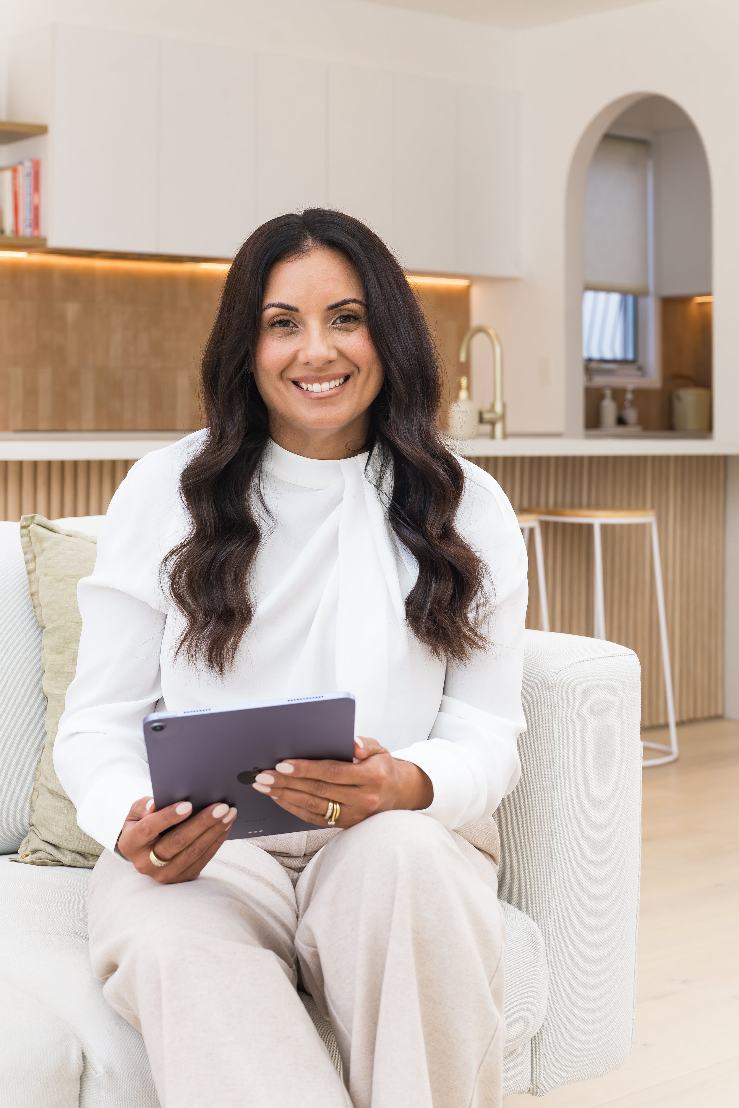 Tiana Tait, founder of Insight Strategy Co., seated and holding an iPad.