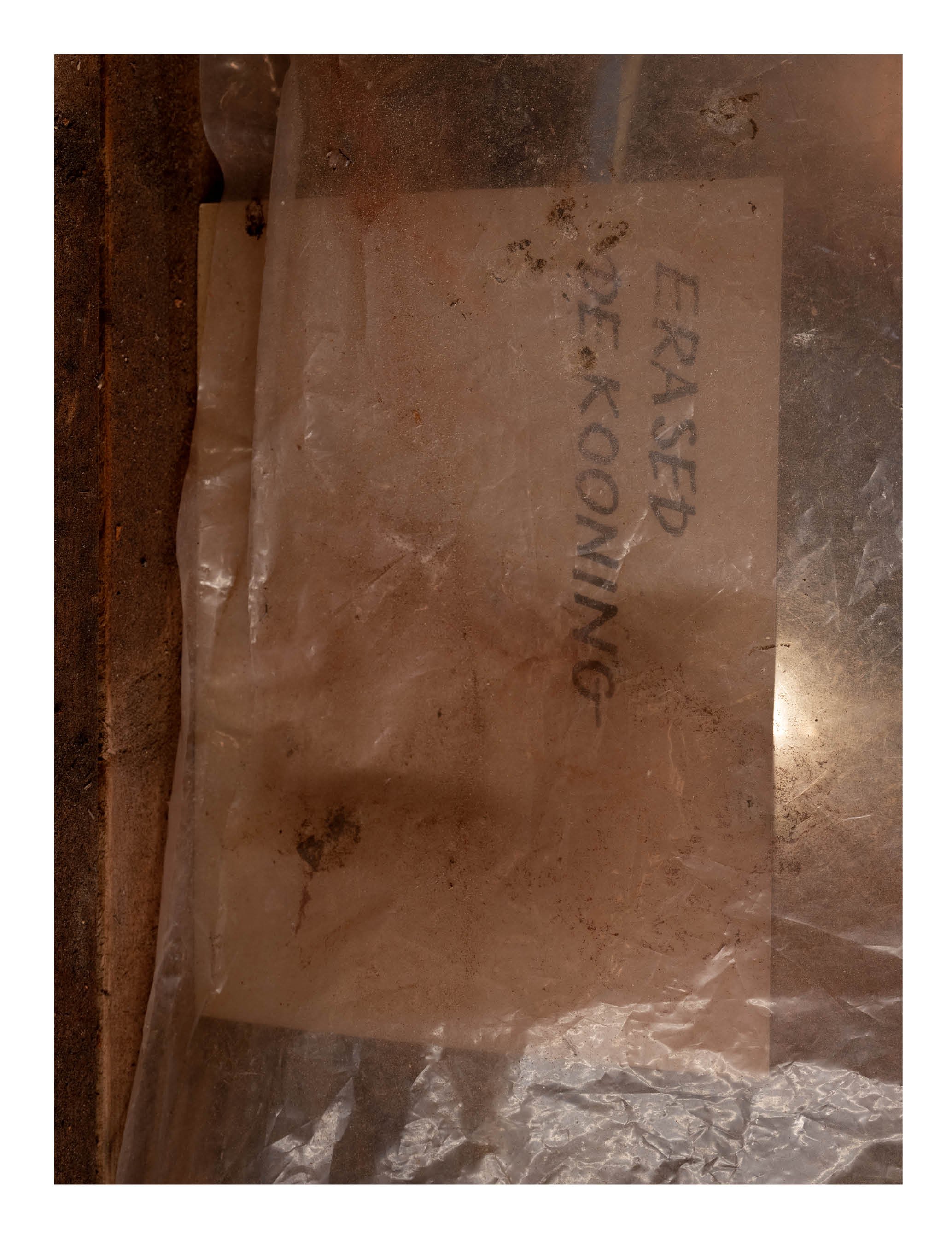 A piece of rock or stone with the words 'ERASSED OVER' handwritten on it.