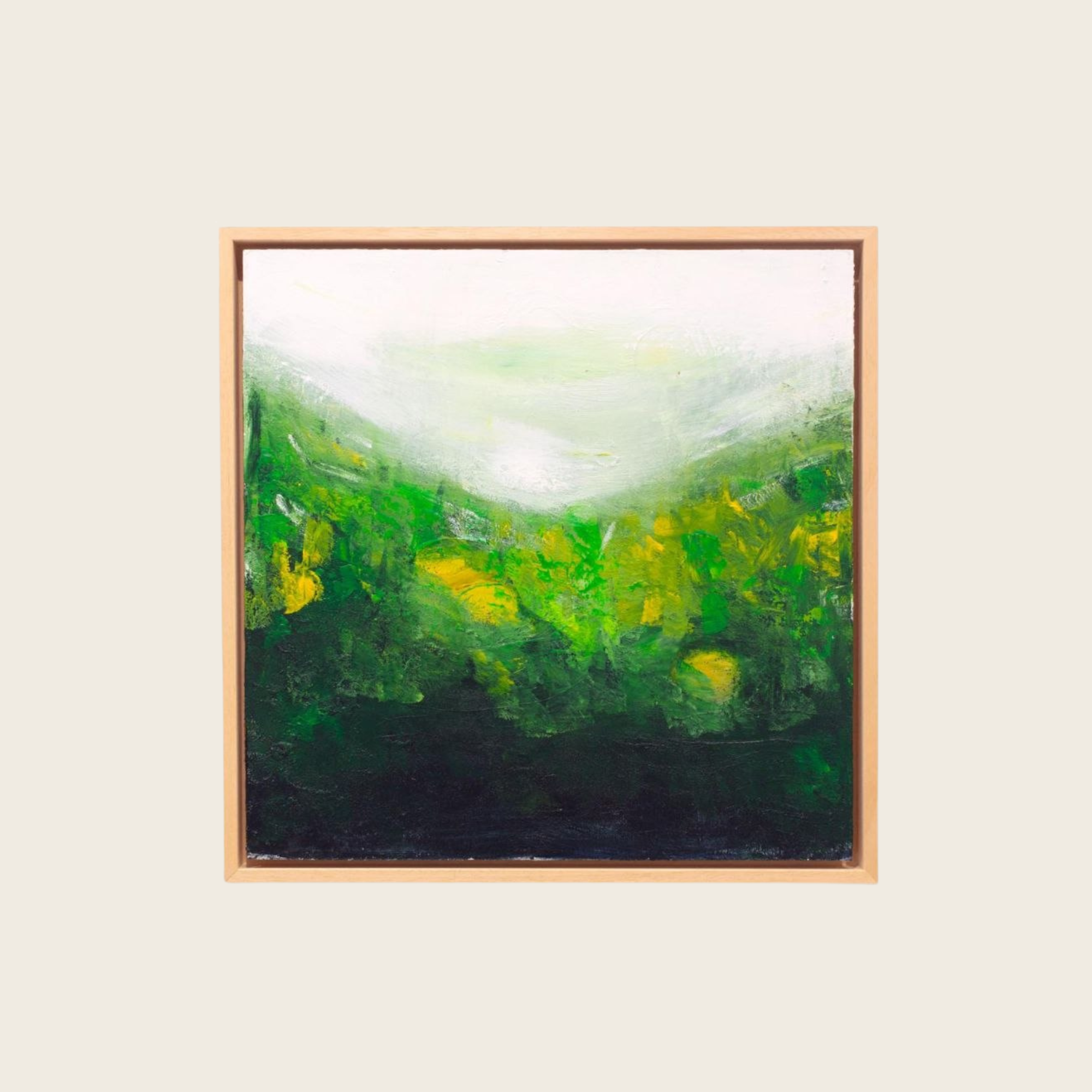 An abstract painting with green, yellow, white, and black brushstrokes framed in light wood, displayed against a plain wall.