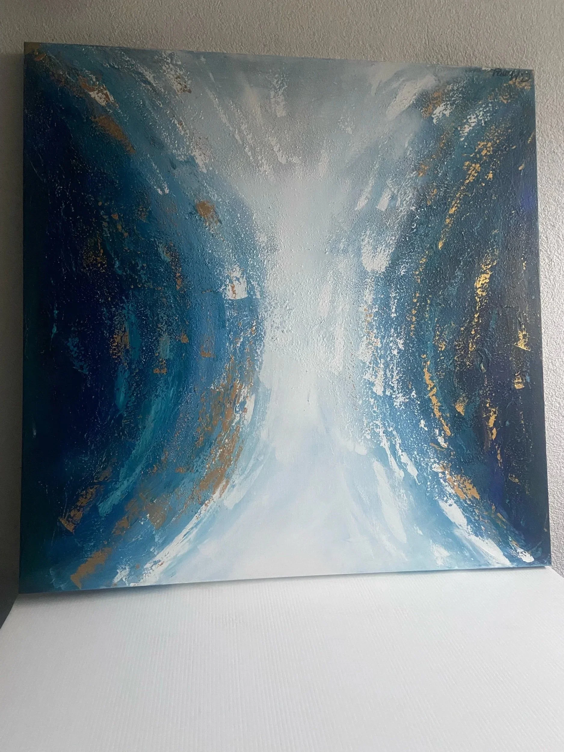 Abstract painting with shades of blue, white, and gold, featuring textured and swirling brushstrokes.