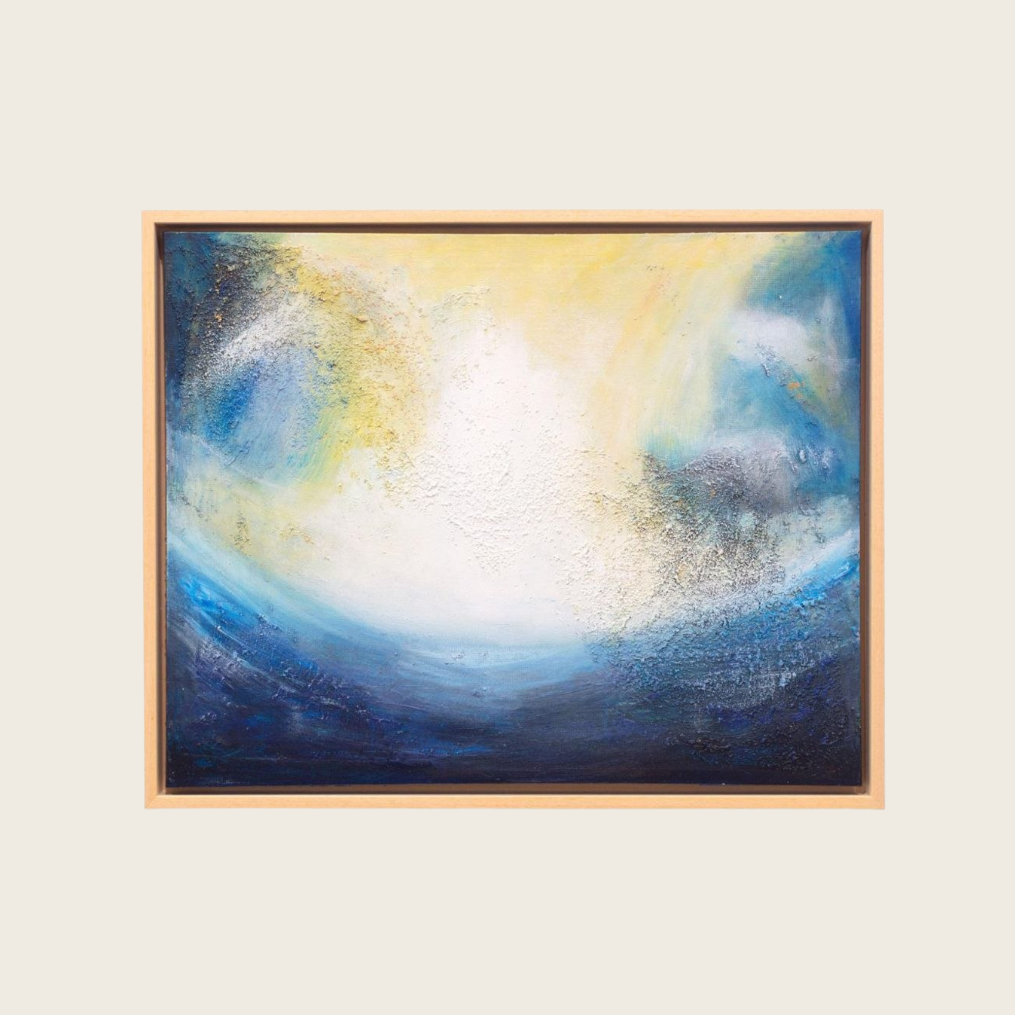 An abstract painting with a mix of yellow, white, blue, and black colors, framed in light wood.