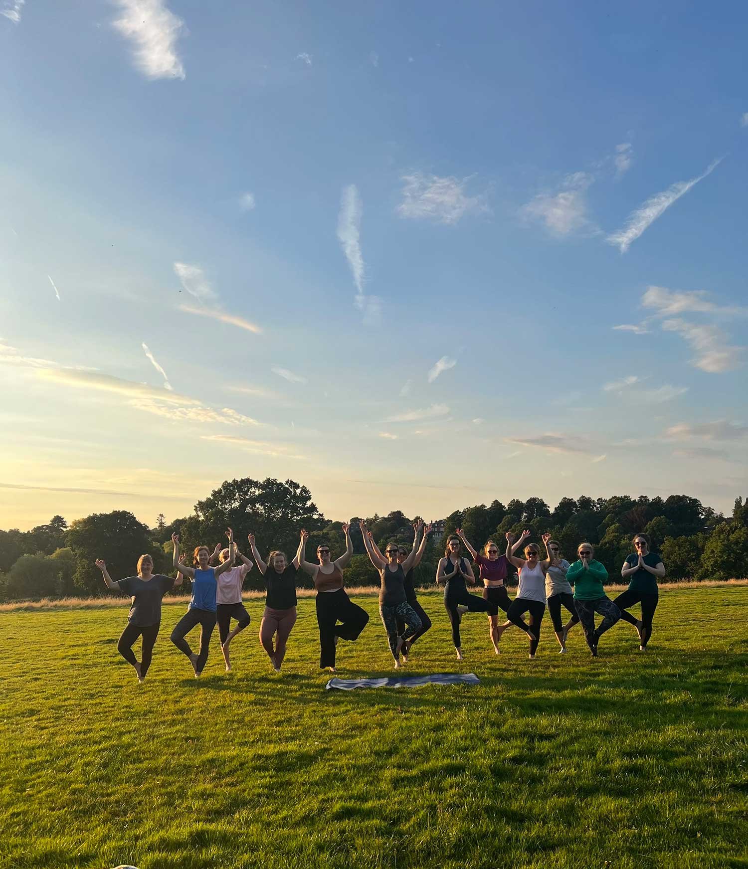 Group of people participating in outdoor yoga At Abbey Fields park, Kenilworth.