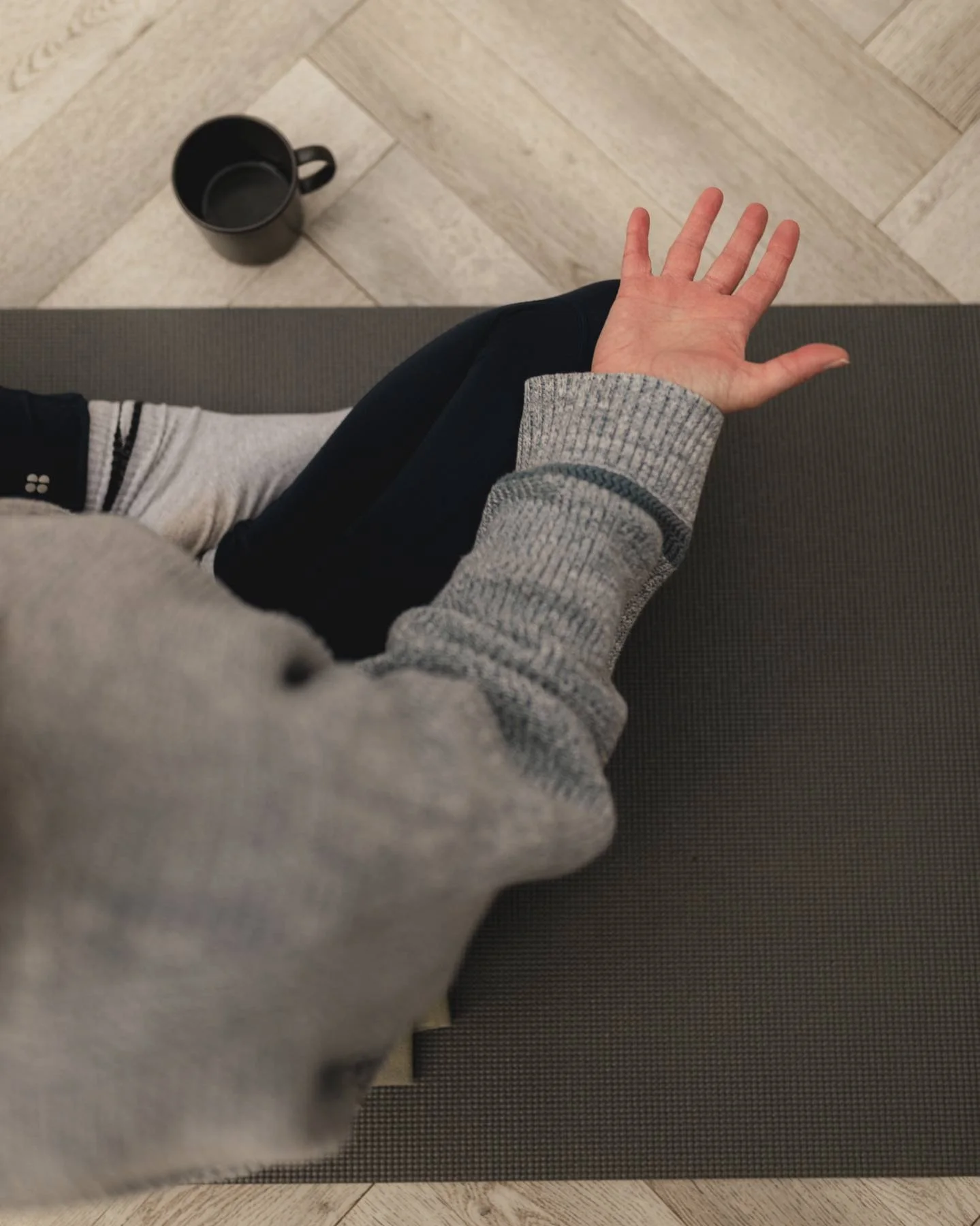 Top-down view of a person's hand resting on their knee at The Basement Snug Yoga Studio in Kenilworth.