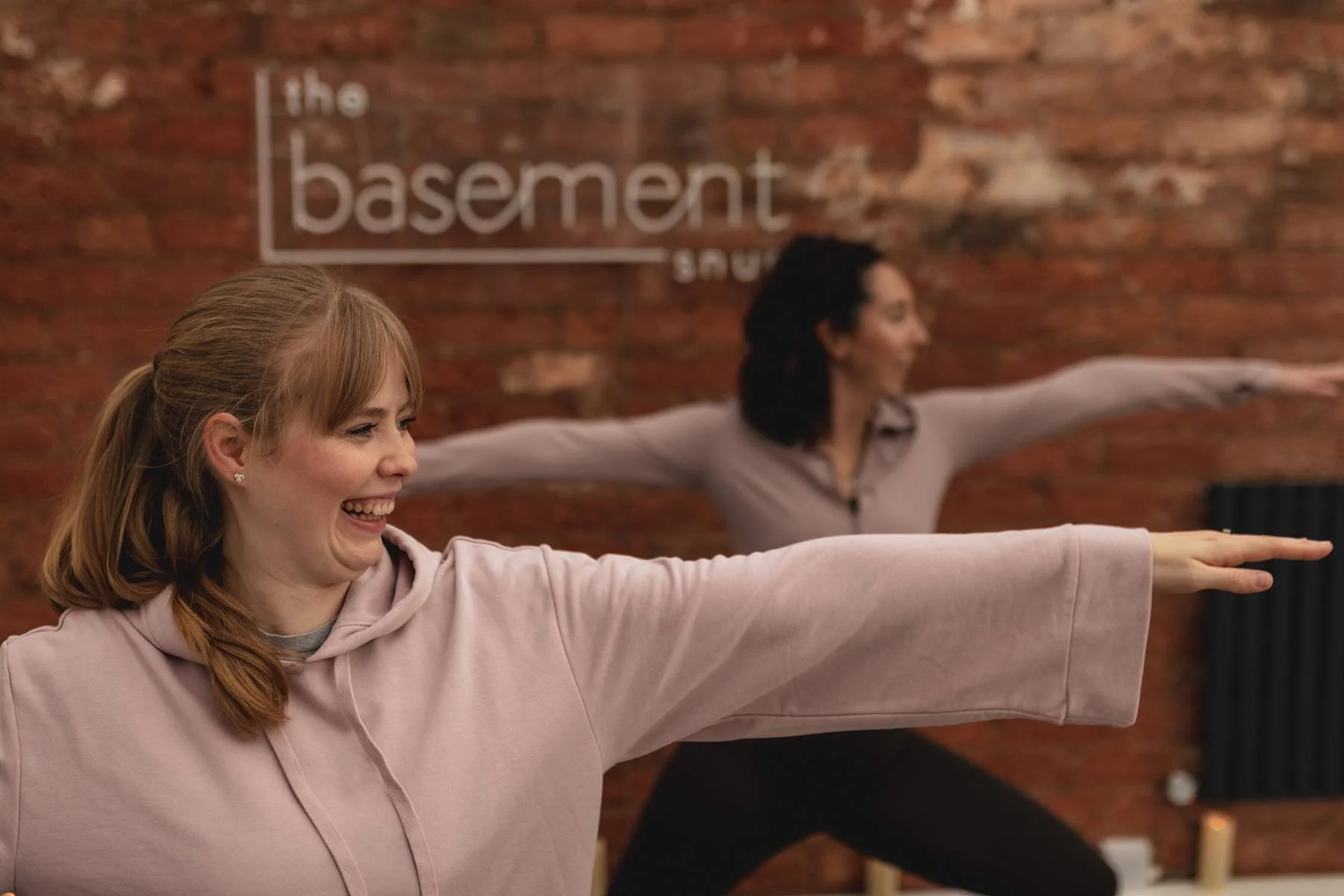Two women practicing yoga in The Basement Snug Yoga Studio in Kenilworth.