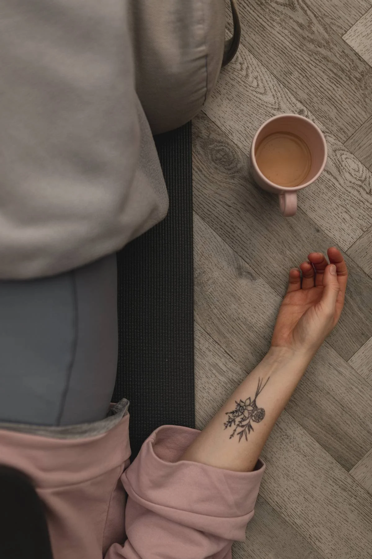 A person lying on a yoga mat on a wooden floor at The Basement Snug Yoga Studio in Kenilworth.
