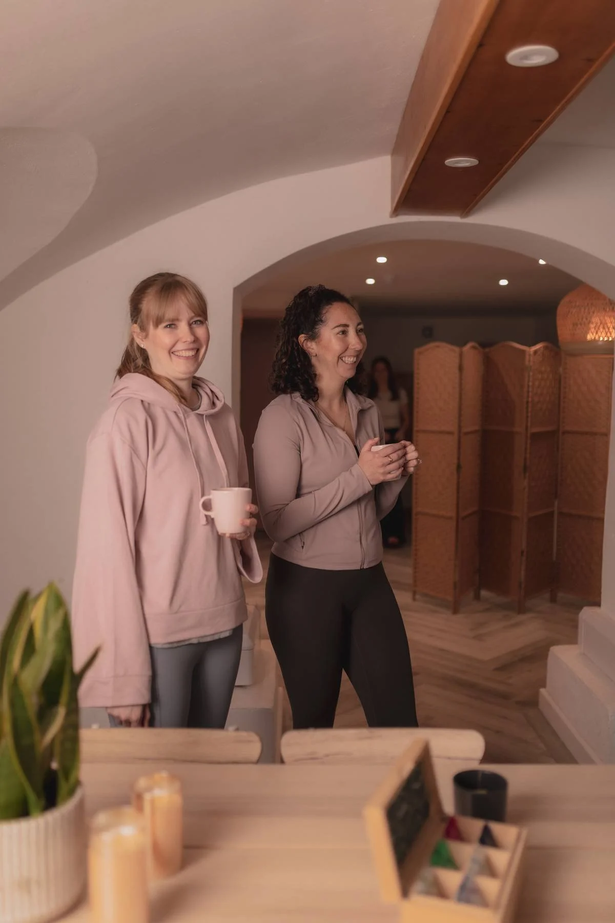 Two women standing indoors, at The Basement Snug Yoga Studio in Kenilworth.