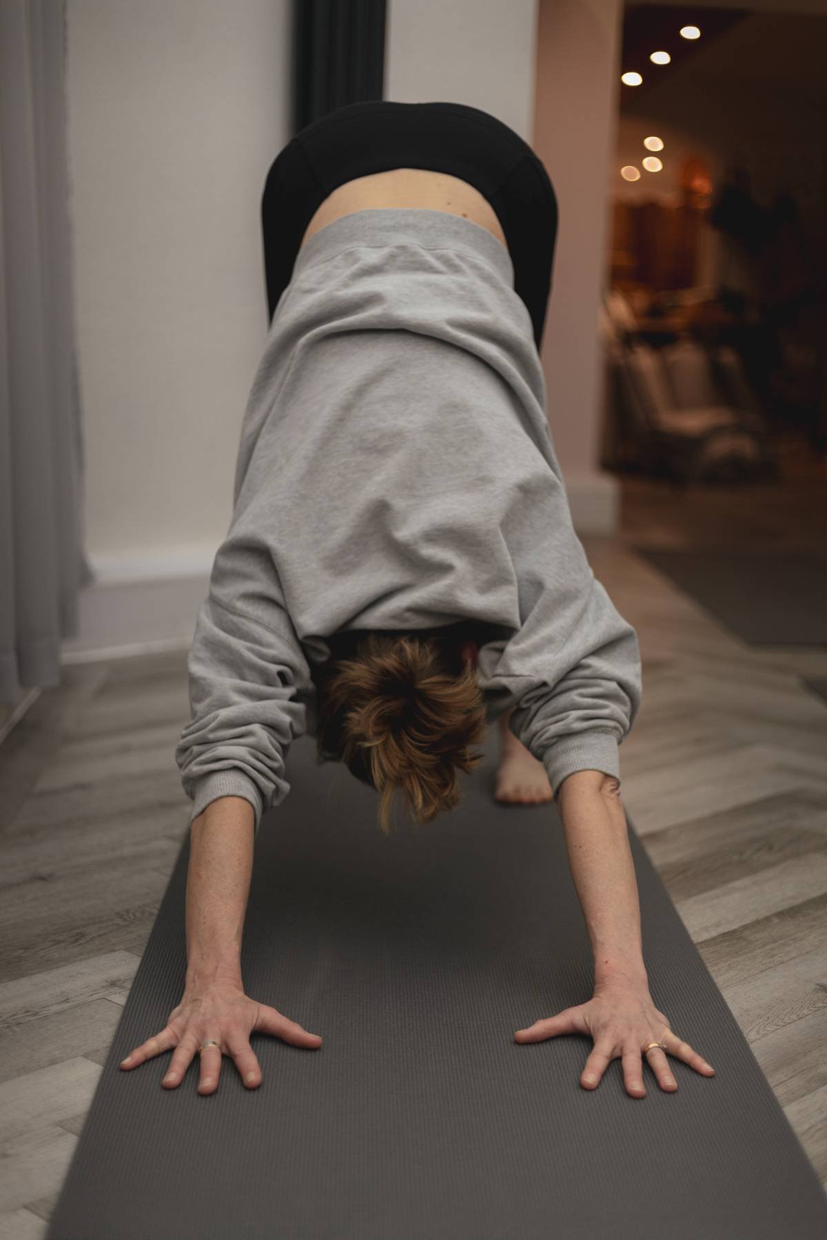 A person with short hair doing a yoga pose on a mat in a room at a Kenilworth yoga studio.