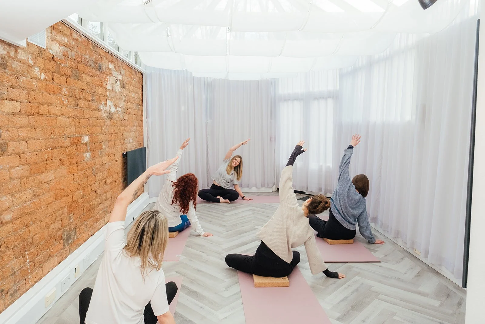 Group of women participating in a yoga class in a bright studio at The Basement Snug Yoga Studio in Kenilworth.