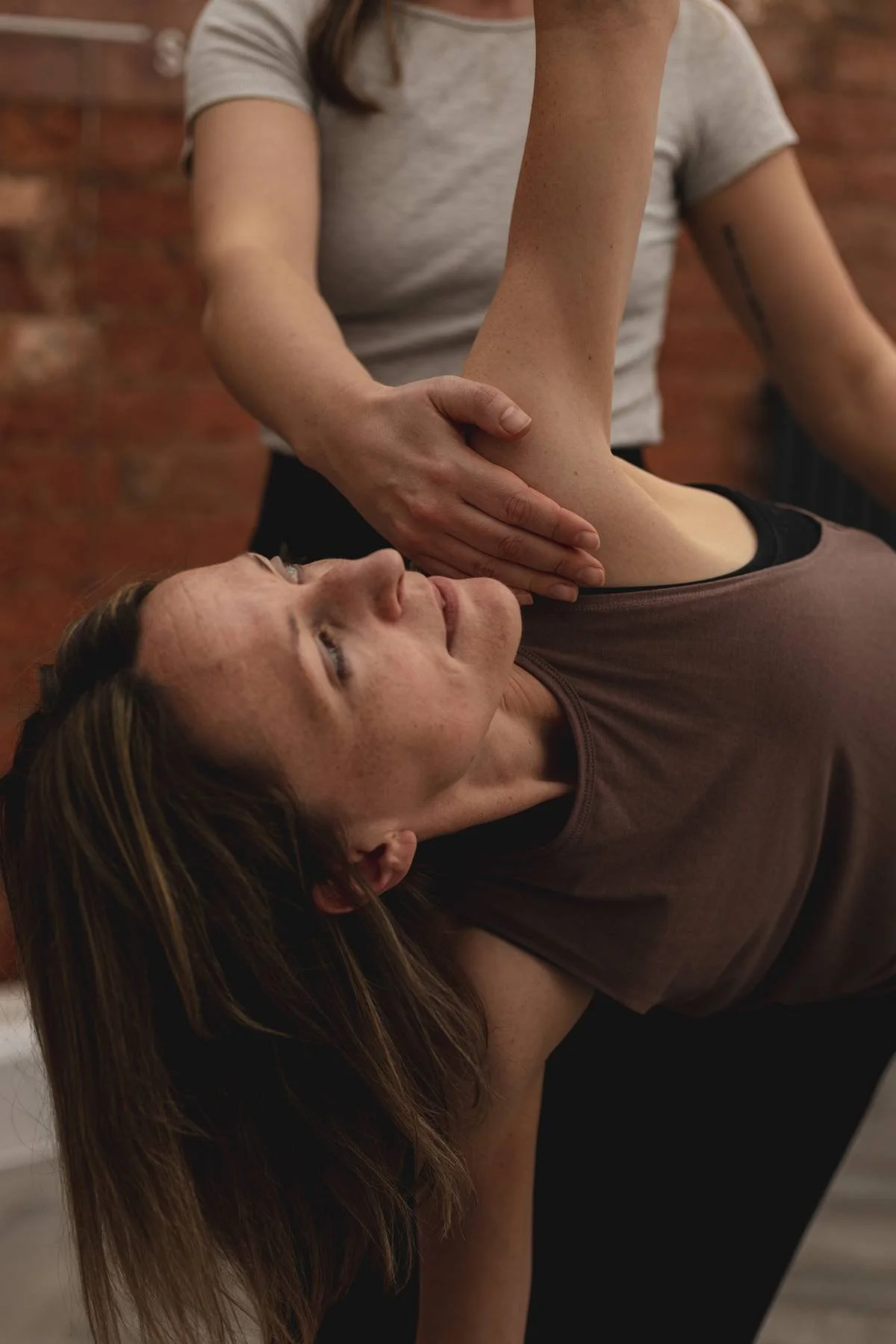 A woman receiving a yoga correction at The Basement Snug Yoga Studio in Kenilworth.